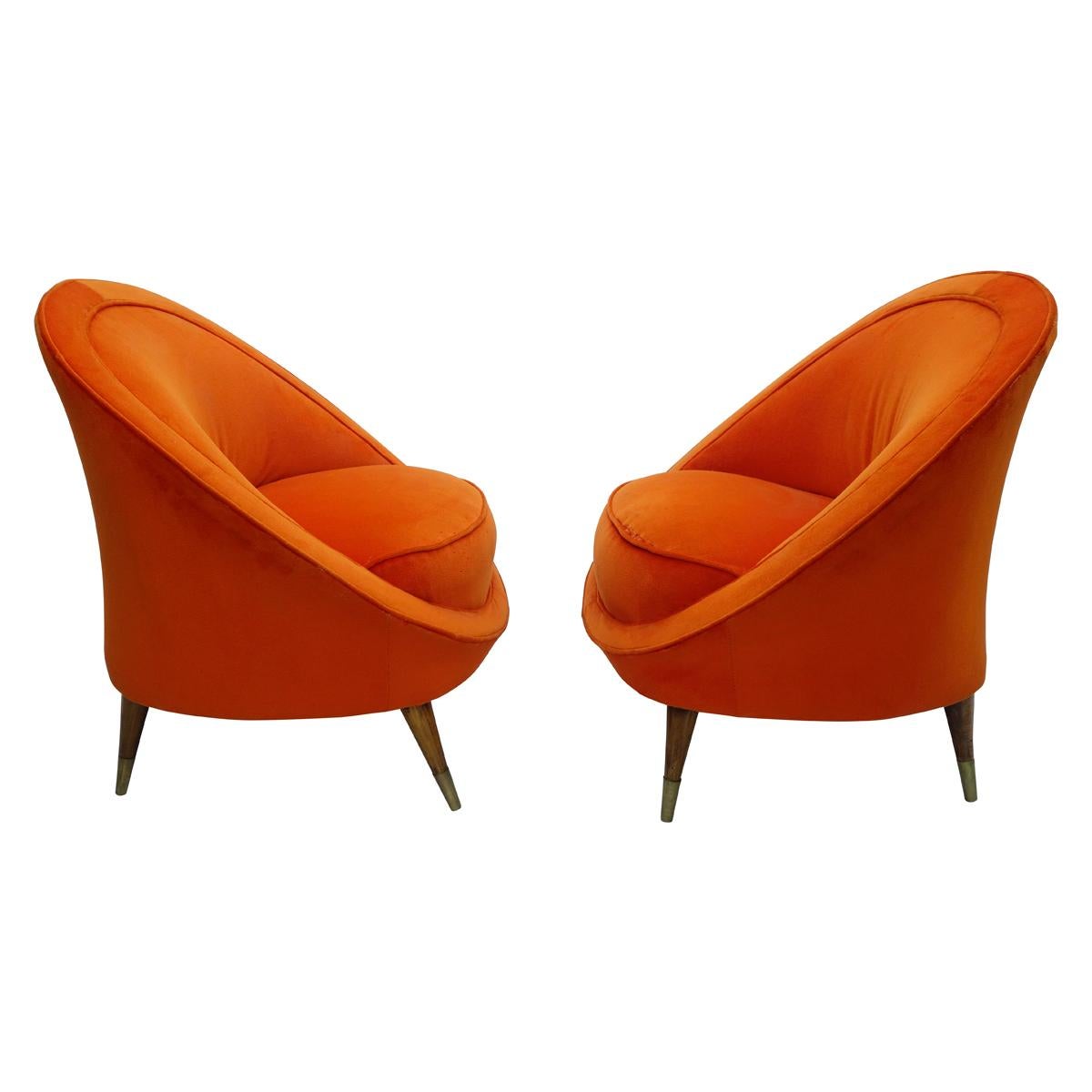 Pair of Italian orange velvet barrel back club chairs in the manner of Gio Ponti. Splayed wood legs with brass 