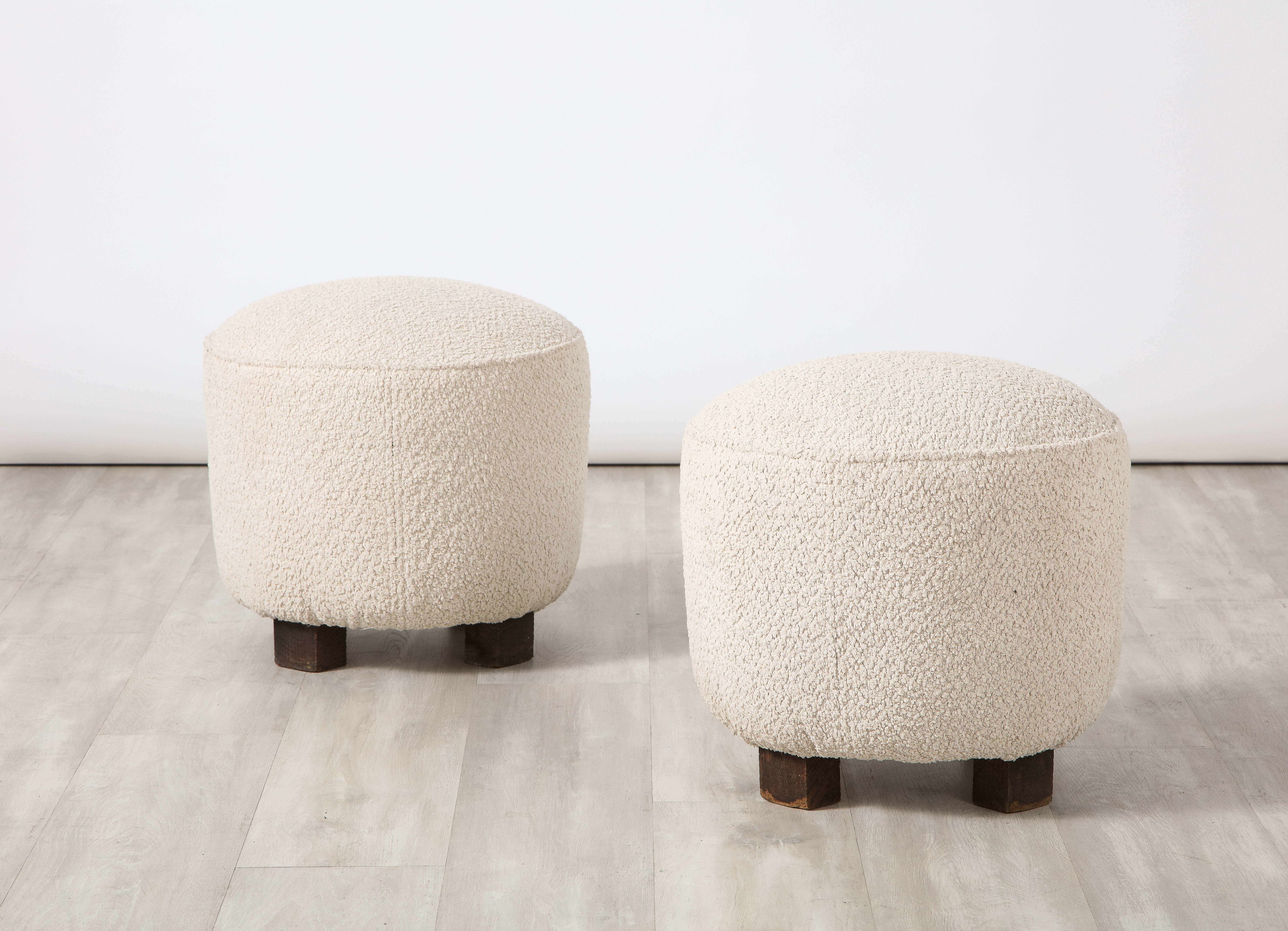 A wonderful pair of Italian Organic Modern circular stools, upholstered in a creamy white wool boucle, supported on three rough hewn wooden feet. Perfect for pulling up fireside in the city or the country! 
Northern Italian, circa 1960 
Size: 17