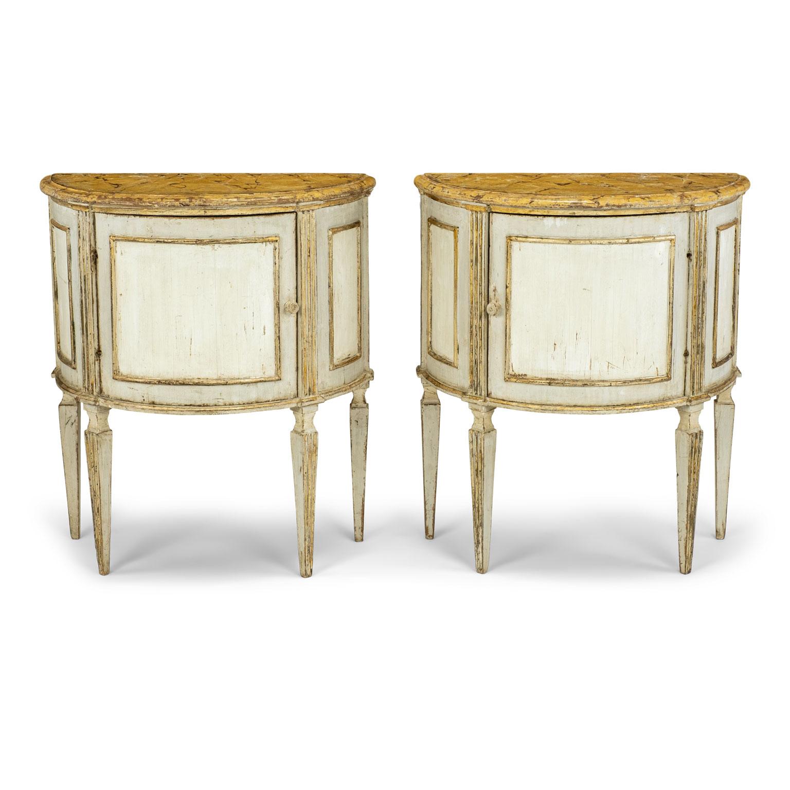 Pair of Italian painted demilune console tables with faux marble tops. Mid-19th century demilune console tables painted with gilt detail. Interior cabinet storage accessed by single door in front of each table. Perfect as nightstands or side tables.