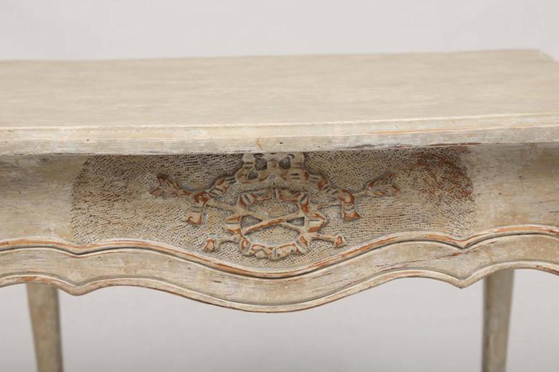 Coppia di tavolini dipinti, ciascuno dei quali ha un piano rettangolare modanato, il grembiule a serpentina intagliato con motivi neoclassici, un singolo cassetto a fregio sul lato stretto del tavolo, sollevato su gambe cabriole a sezione quadrata,