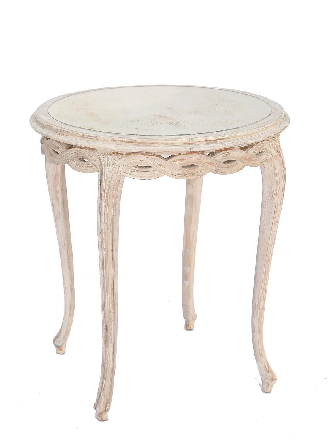Pair of end tables, each having a round top of spotted mirrorplate, having a painted table base showing natural wear, its pierced apron carved into braided evolute scroll, raised on cabriole legs. 

Stock ID: D9266.