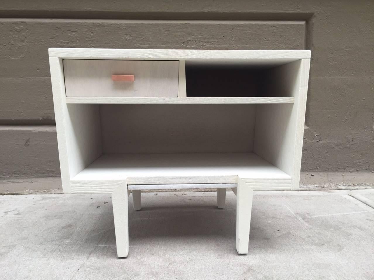 Pair of Italian painted nightstands style of Gio Ponti. Wood nightstands are painted white with an exposed grain finish. Has a single pullout drawer with copper hardware and a pullout tray at the bottom. Mid Century Modern.
