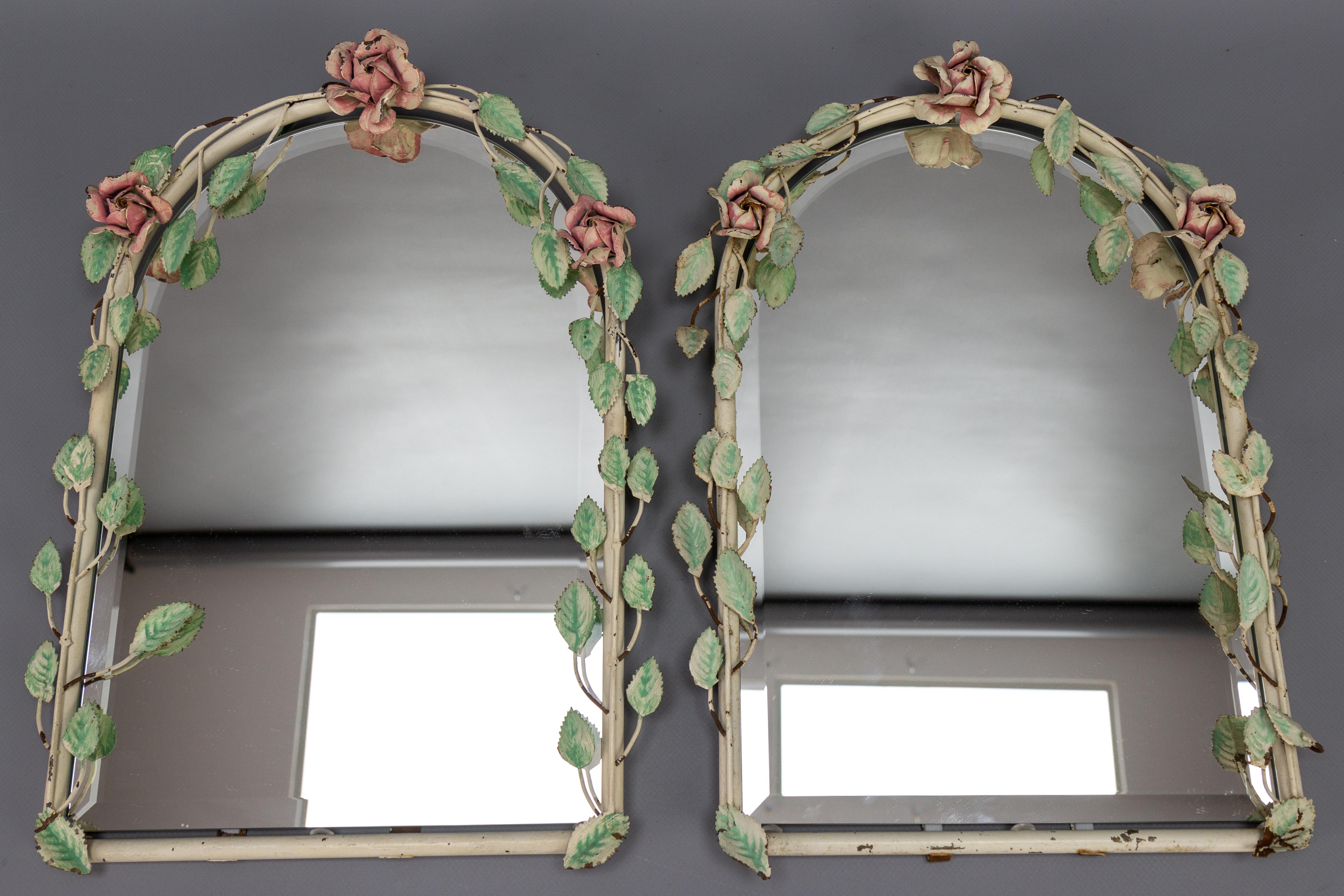 Pair of Italian painted tole flower wall mirrors, 1950s.
This beautiful pair of Italian wall mirrors features a tole-painted pastel color frame with roses and rose leaves and beveled edge mirrors.
In good condition with some flaking to paint and