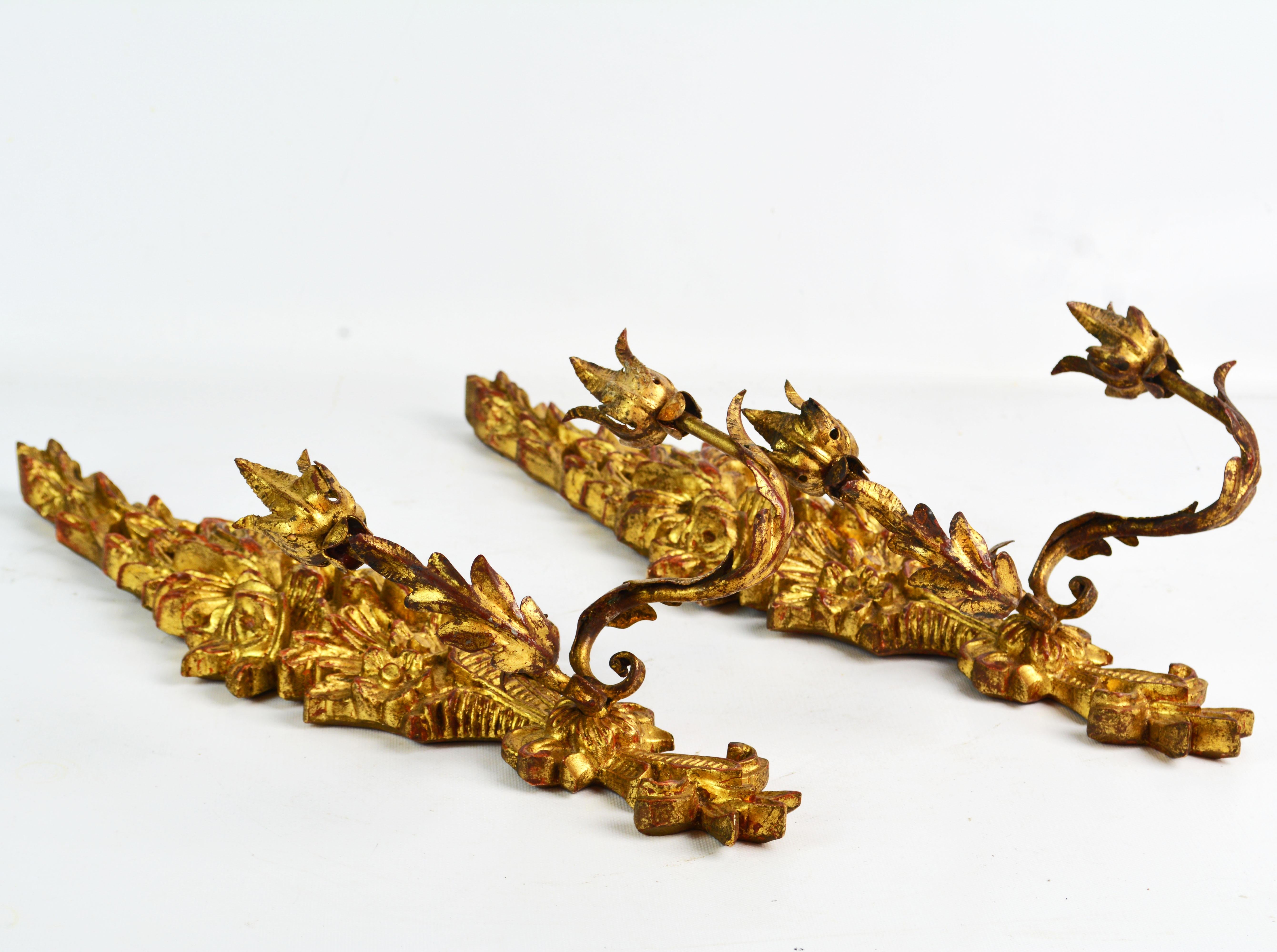 This well carved pair of Louis XV style wall sconces are made by the legendary Palladio firm in Italy in the mid-20th century. The feature a main body carved with foliage and scrolls in the Rococo style and two gilt metal light arms with applied