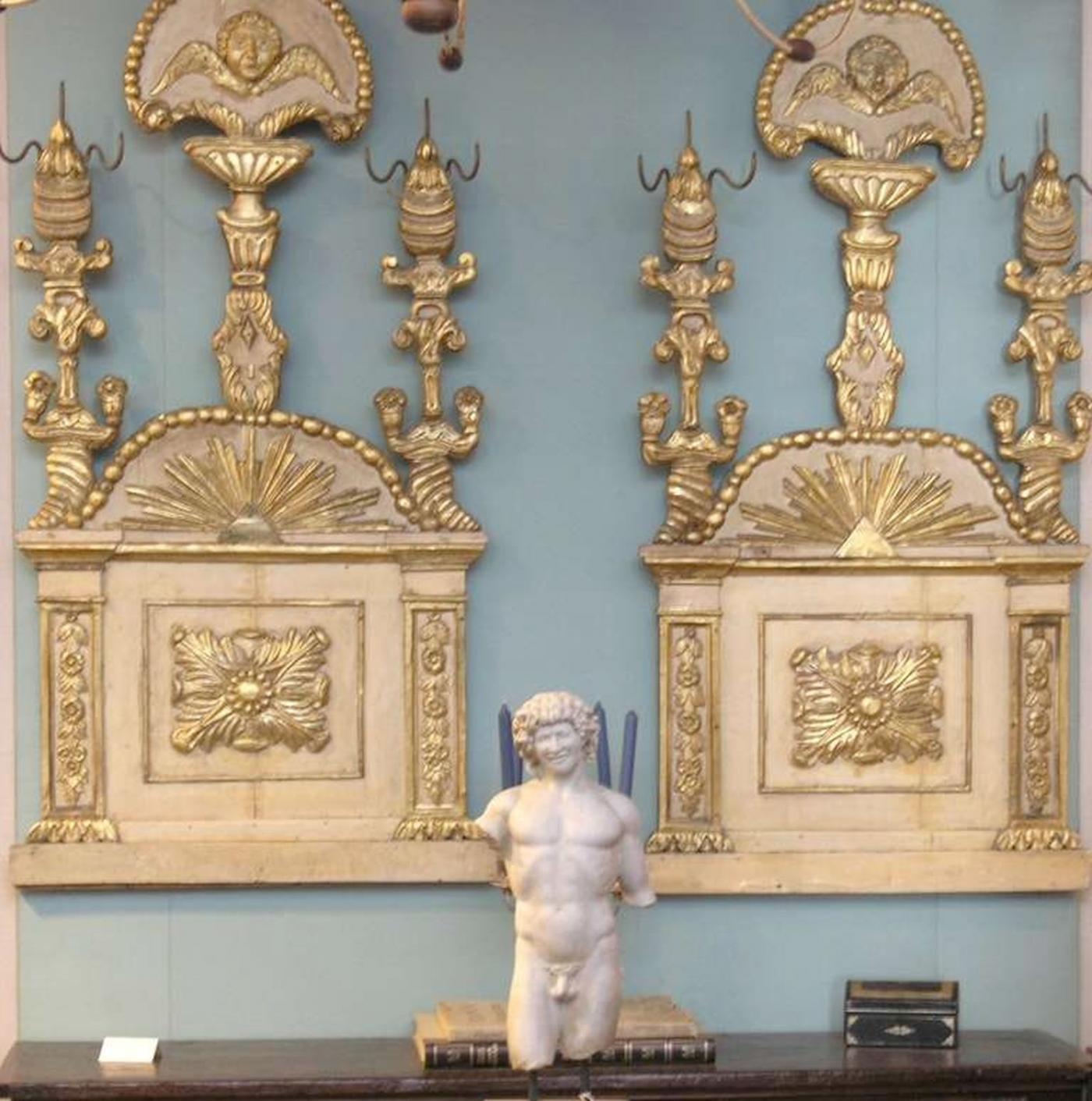 Pair of Italian painted and parcel gilt panels. Bouquet finial supported by cherub in beaded frame , Three carved vertical columns of twisting floral forms. Carved sunburst pattern above central square framed with pilasters