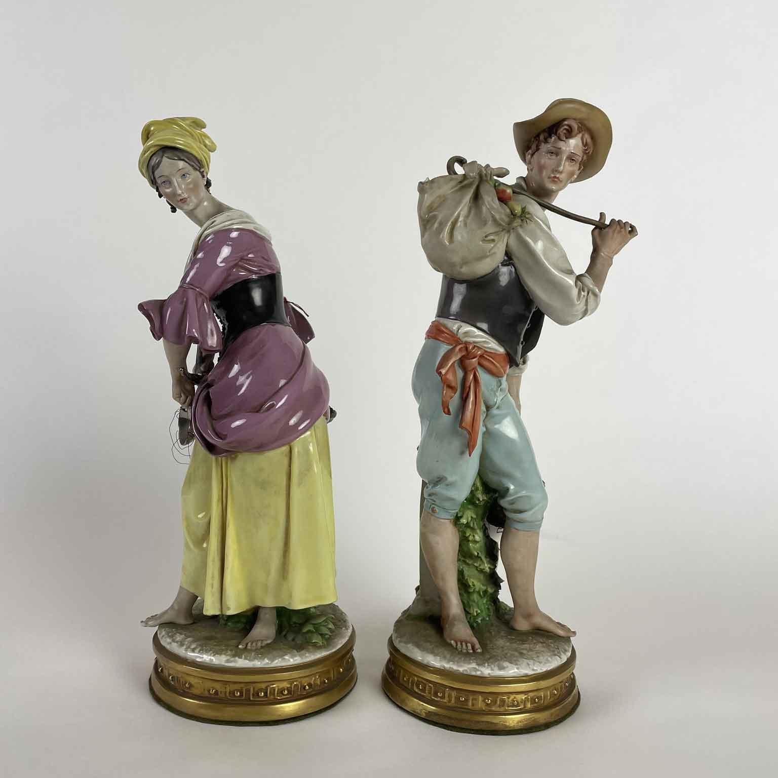 Pair of hand-painted polychrome porcelain sculptures depicting the allegory of abundance, two peasants, a girl and a young boy, holding fruit and grapes baskets. 
Both porcelain figures have wonderful details stand on a golden circular base,