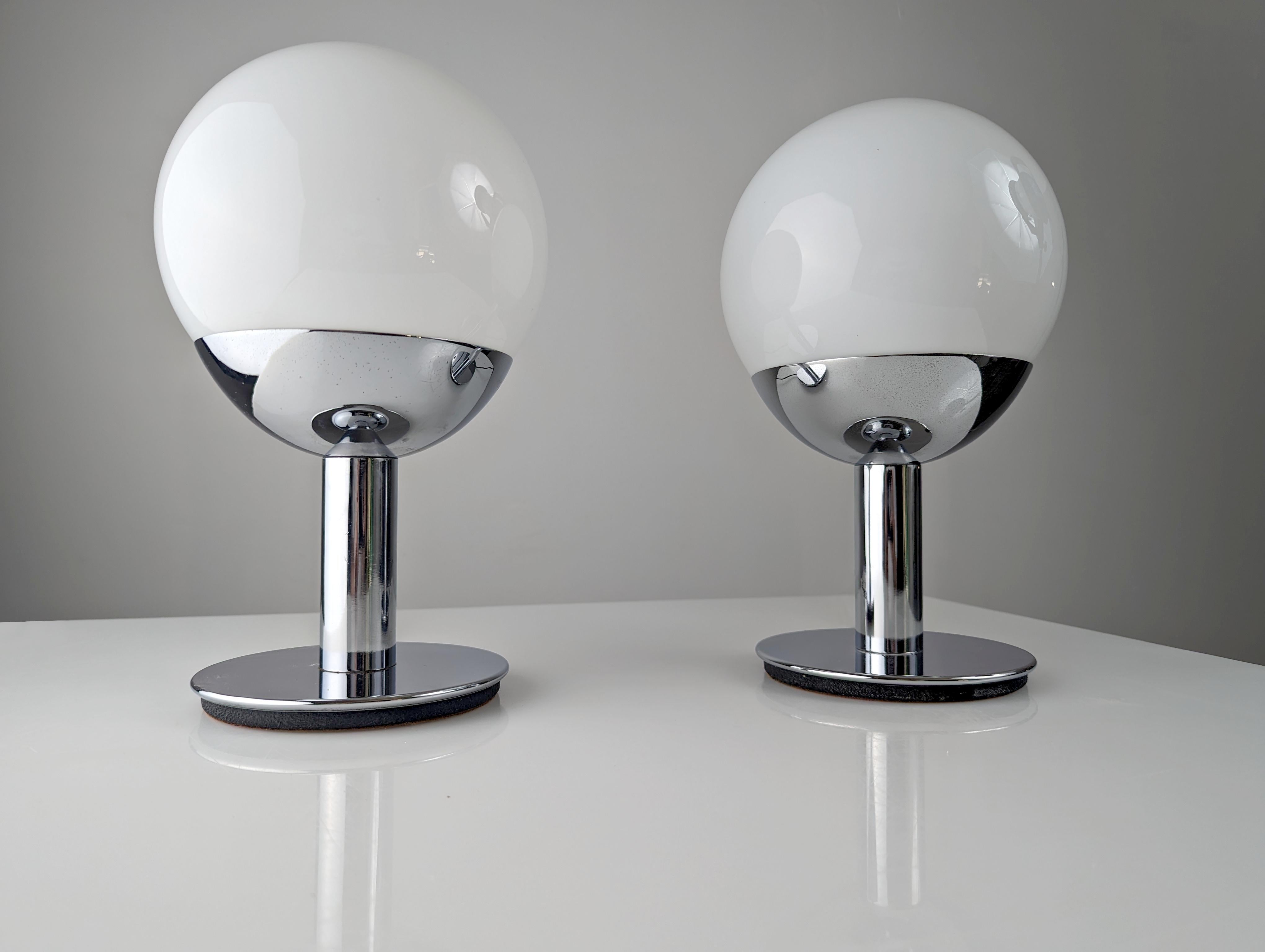 Wonderful pair of chrome lamps attributed to the great Italian designer Pia Guidetti Crippa who made these fantastic globe designs on enveloping brass and chrome metal bases in the middle of the century for LUCI Illuminazione. The combination of