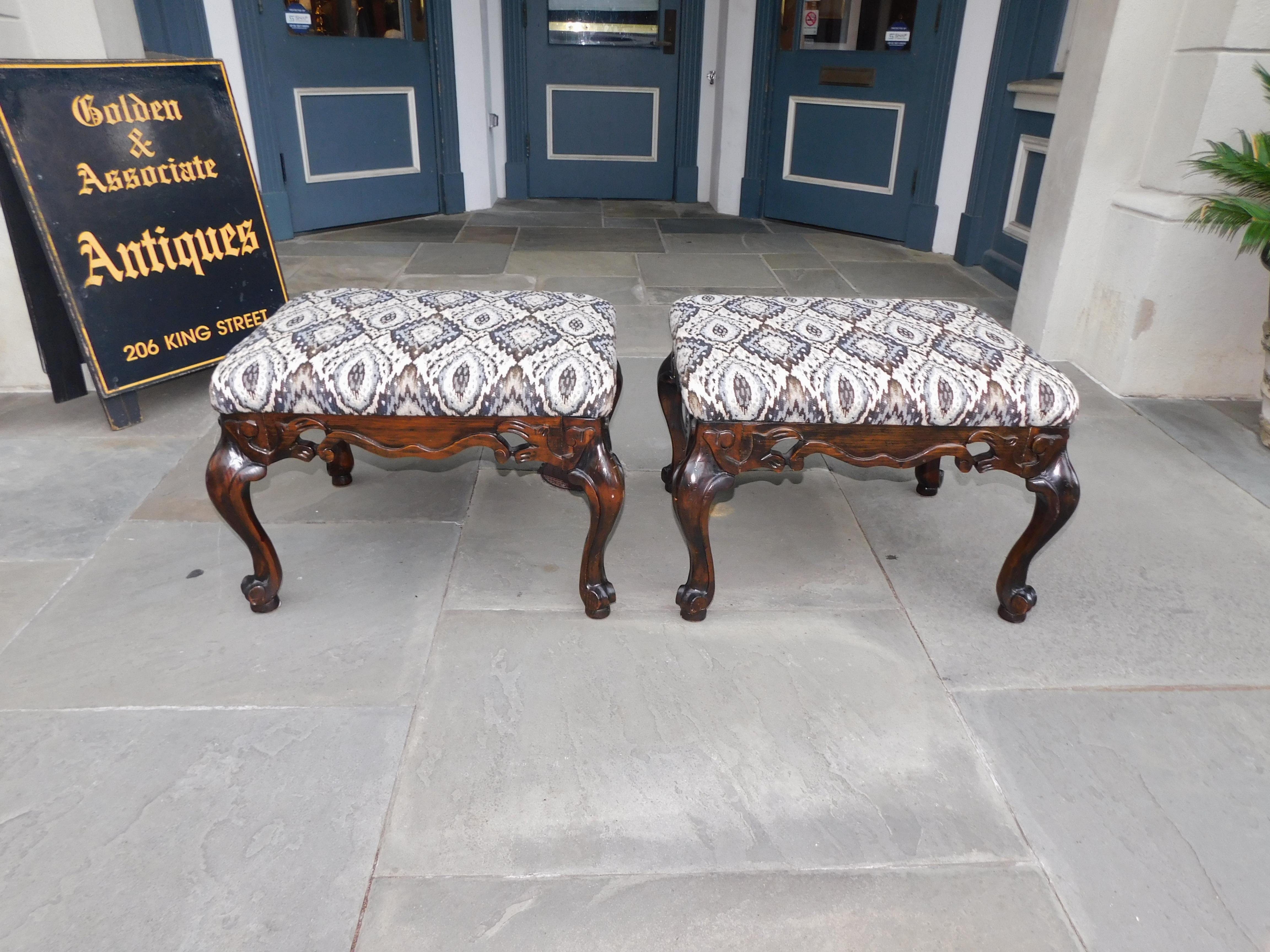 Pair of Italian baroque style upholstered benches with flanking carved serpentine skirts, and resting on the original cabriole legs with pad feet. Late 19th century.