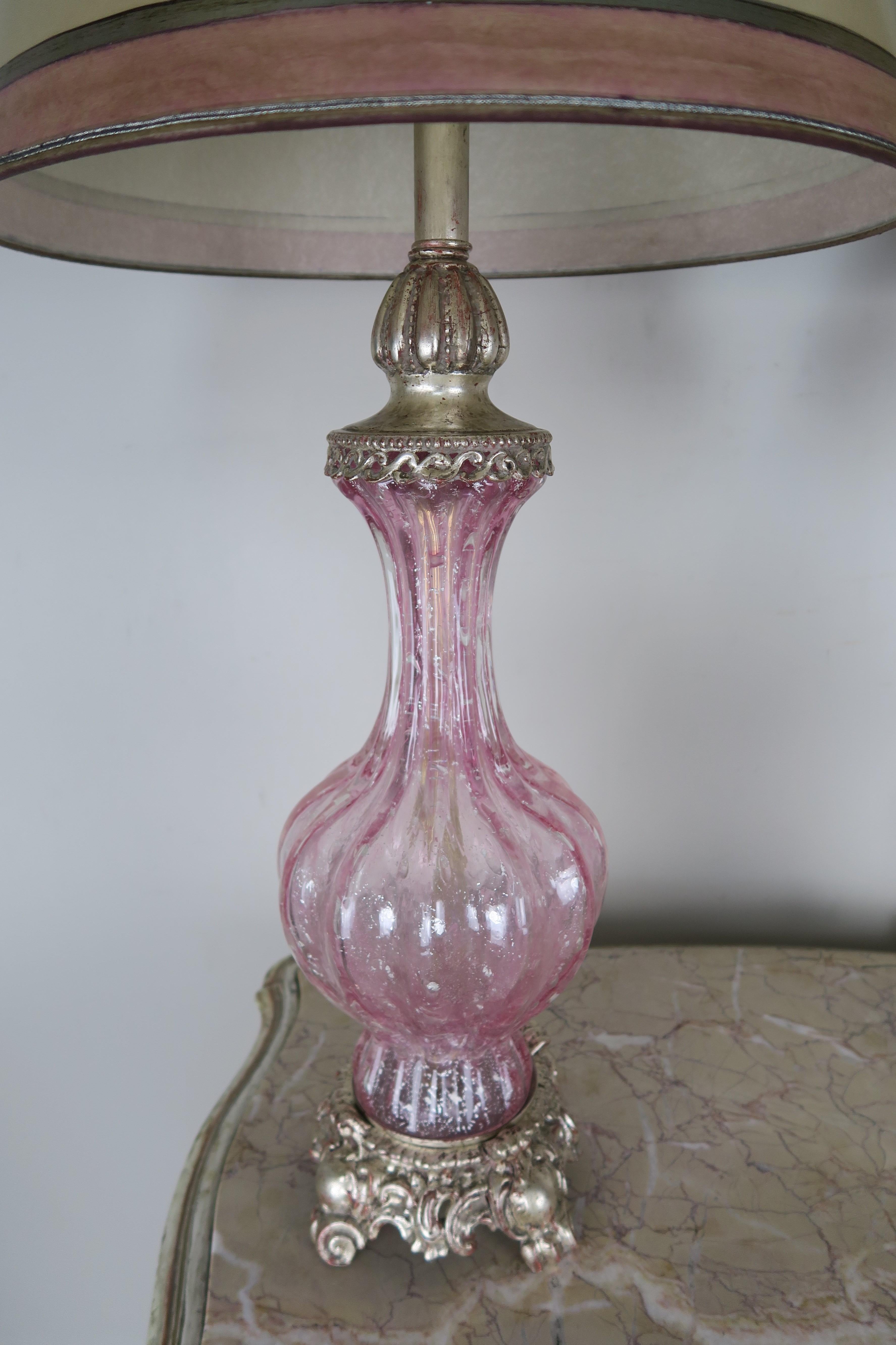 Pair of Italian pink Murano glass lamps standing on silver leaf metal bases. The shades are hand painted parchment in coordinating colors of pink and silver. The lamps are newly rewired and are in working condition.