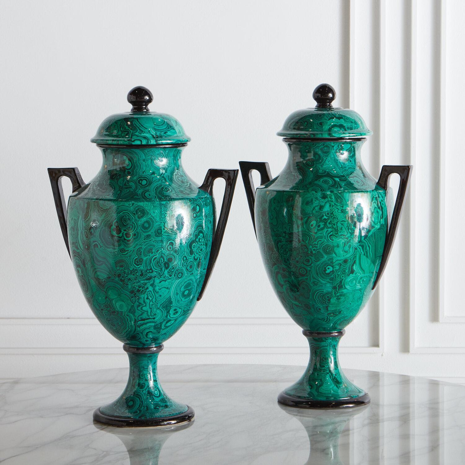 A stately and handsome pair of porcelain urns with Neoclassical motif handles and removable lid; marked “Italy” on underside. Circa 1980’s, Italy.