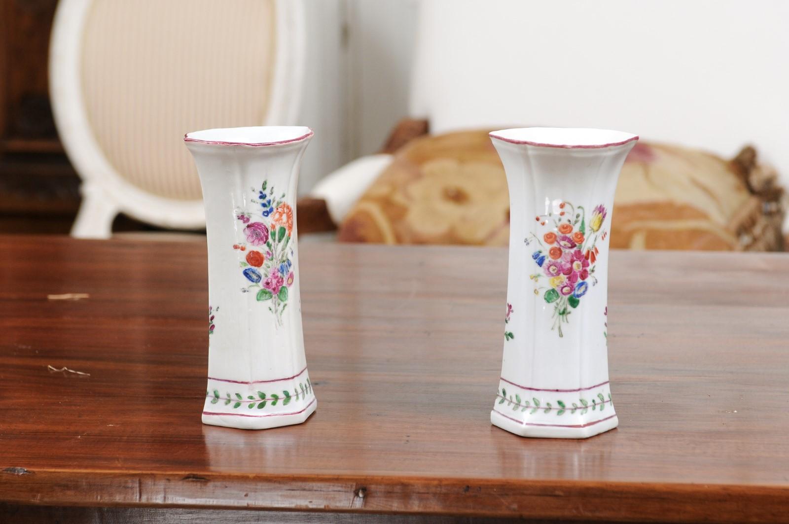 A pair of Italian porcelain vases from the early 19th century, with painted floral decor. Created in Italy during the first decade of the 19th century, each of this pair of porcelain vases features a splaying body, delicately adorned with colorful
