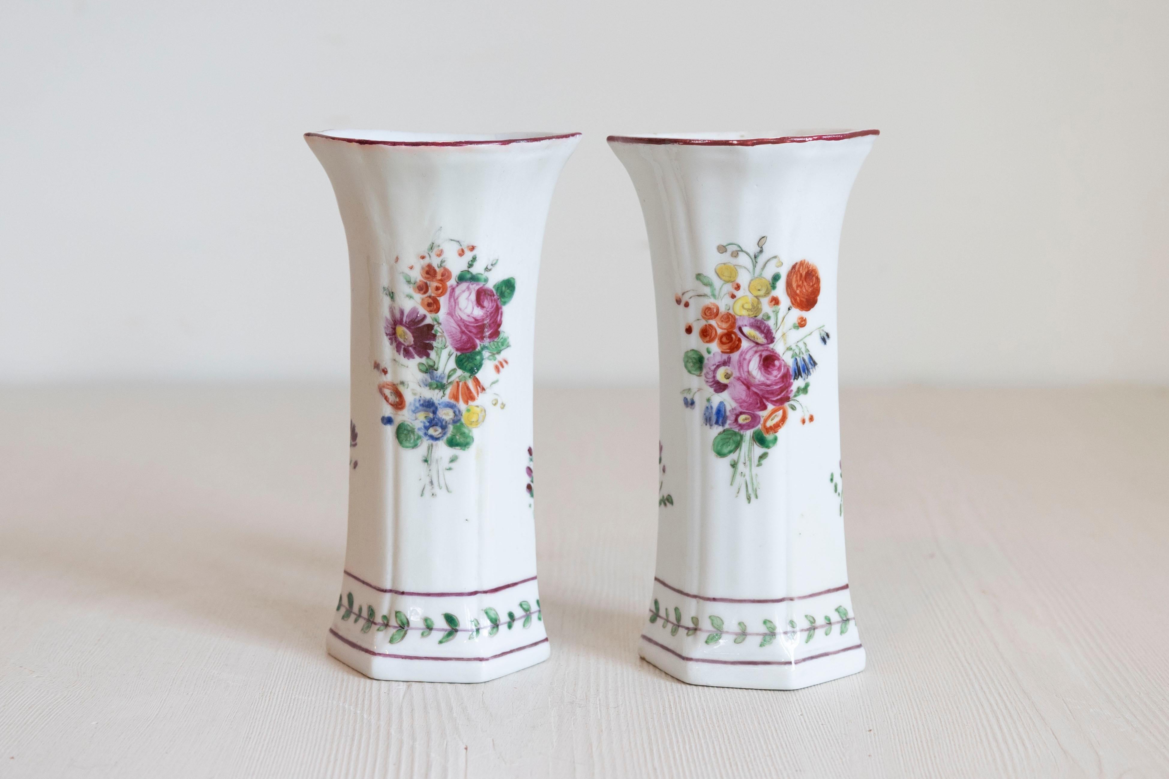 Pareja de jarrones de porcelana italiana de principios del siglo XIX, con decoración floral pintada. Creados en Italia durante la primera década del siglo XIX, cada uno de este par de jarrones de porcelana presenta un cuerpo abombado, delicadamente