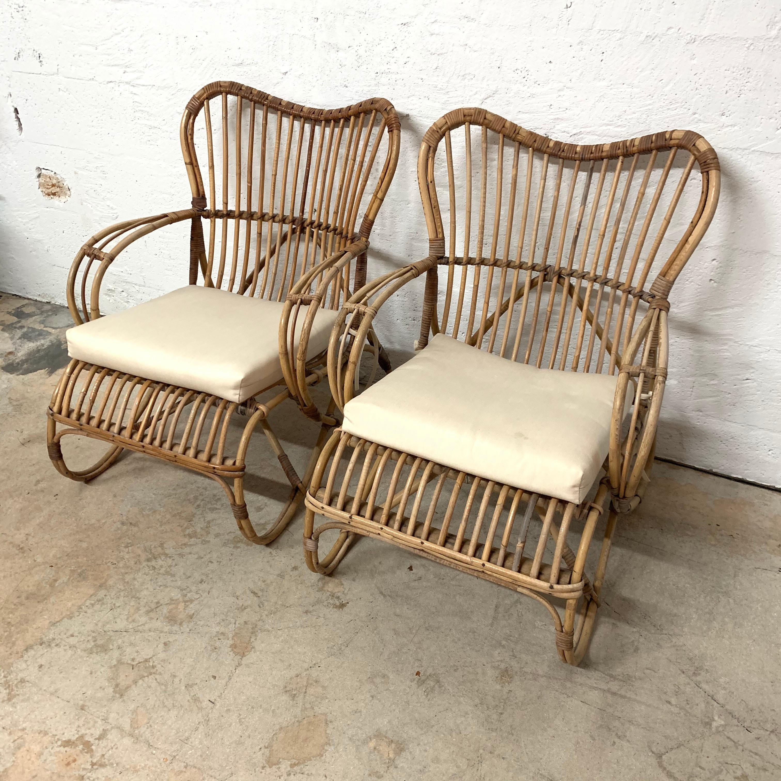 Unique pair of Italian chairs rendered in rattan and wicker with beige off-white cushions.

Rattan, wicker and bamboo.