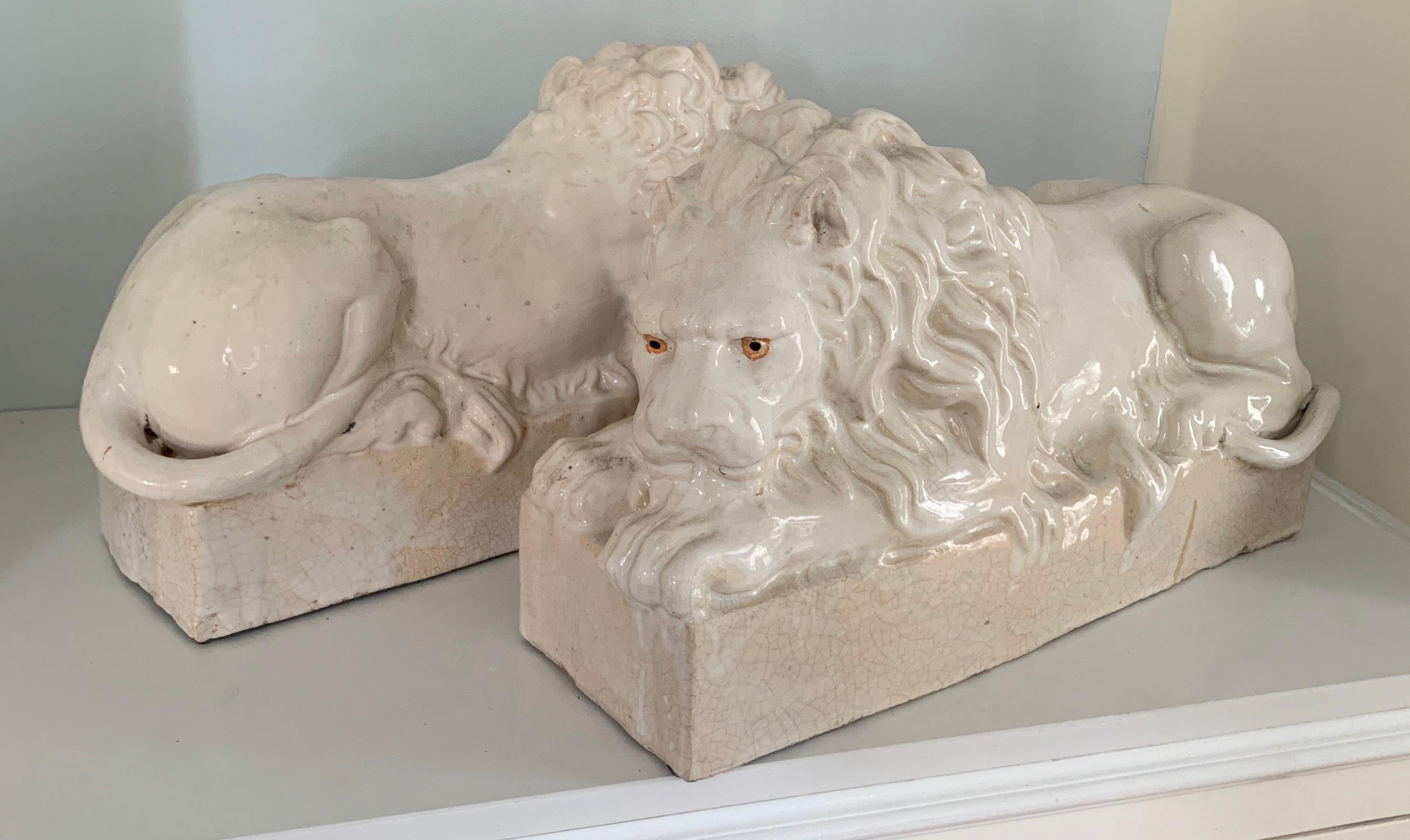 Pair of very large reclining lions in terra-cotta from Italy. The pair are well suited for indoor or outdoor (preferably covered) - flanking a fireplace or on your favorite shelf. A wonderful glazed texture and patina.