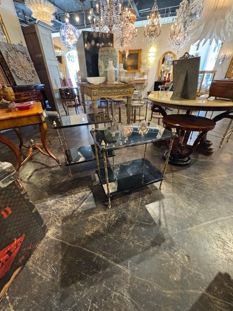 This pair of Italian Regency style tables features a sleek and modern design with a black lacquered finish and bamboo accents giving them a sophisticated look. These gorgeous tables, add a touch of elegance and elevate the overall aesthetic. Perfect