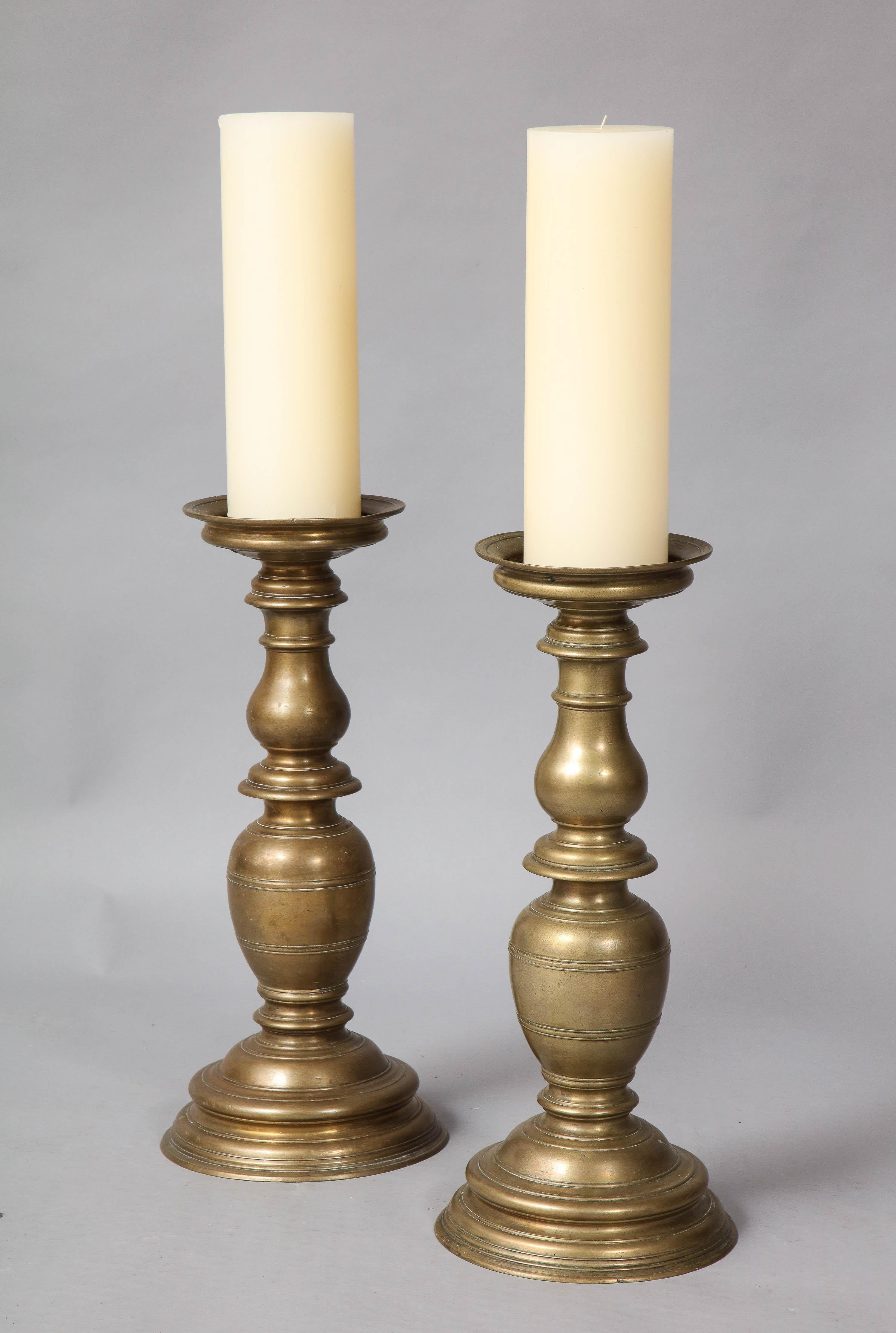 Very good pair of 16th century Italian bronze candlesticks of unusually bold design, turned balustrade form and good scale.
One pricket lacking.
     