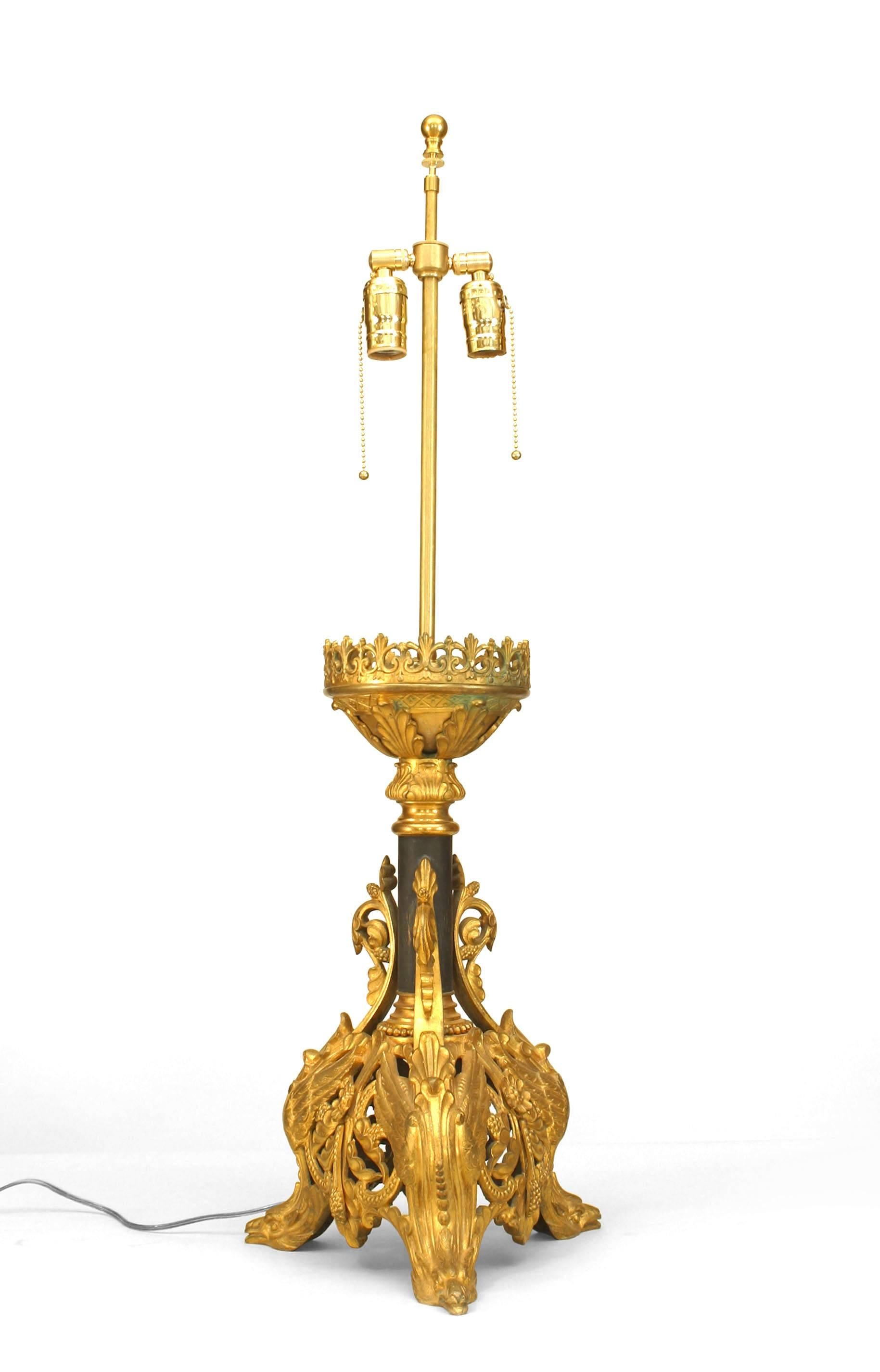 Paire de bâtons d'autel de style Renaissance italienne (19/20e siècle) en bronze doré à base filigranée montés comme des lampes avec 3 pieds à tête d'oiseau ailée et un poteau central ébénisé (PRIX PAR PAIRE).
