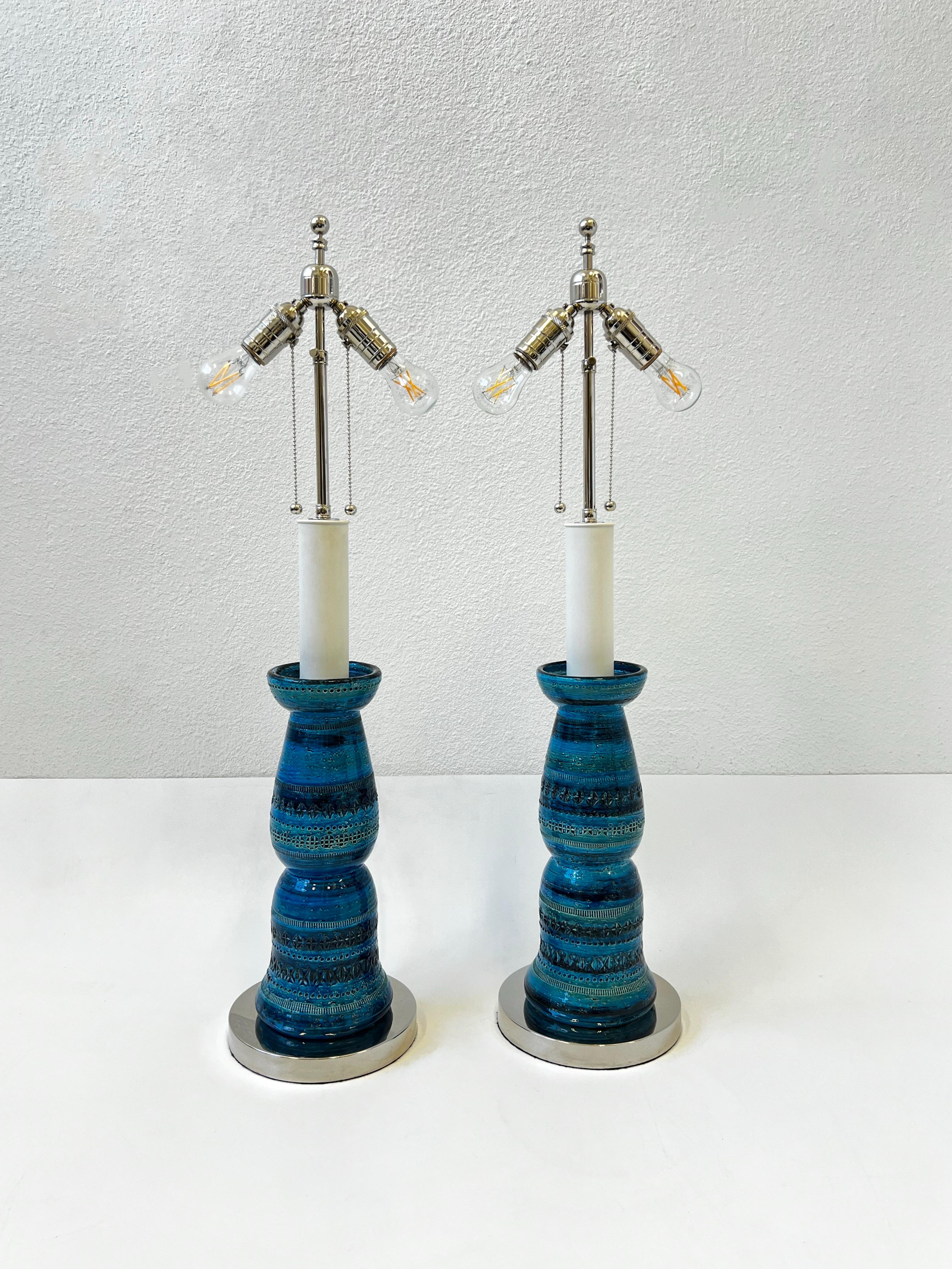 Glamorous pair of 1960’s Italian ceramic ‘Rimini Blue’ table lamps by renowned Italian ceramicist Aldo Londi for Bitossi. 
The ceramic bases are hand made and painted in Italy.
Newly rewired with new polish chrome hardware, black cloth cord and new