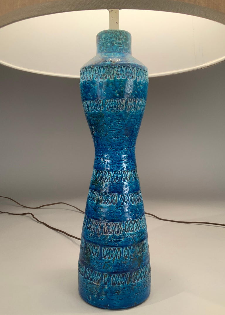 an incredible matched pair of 1950's Italian glazed ceramic lamps made by Aldo Londi for Bitossi. These rare hourglass shaped lamps are glazed in brilliant Rimini Blue, and incised with Londi's classic repeated diamond patterns. they are in