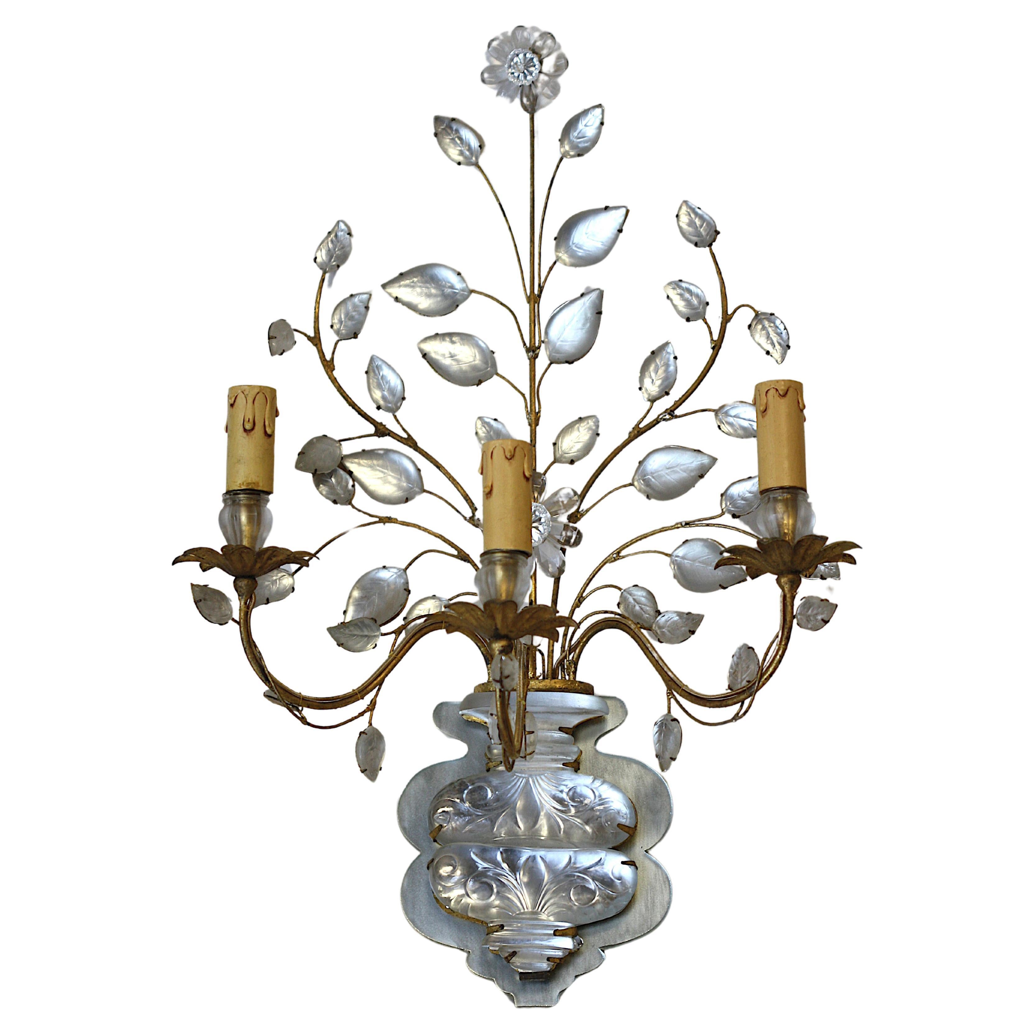 
Pair of Italian Rock Crystal and Gilt Metal Three-Light Wall Lights 
The mirrored and vase-shaped backplate supports three scrolled arms with leaf-shaped drip pans, the vase issuing a foliate spray with leaves and a flowerhead.
Height 25 in. (63.5