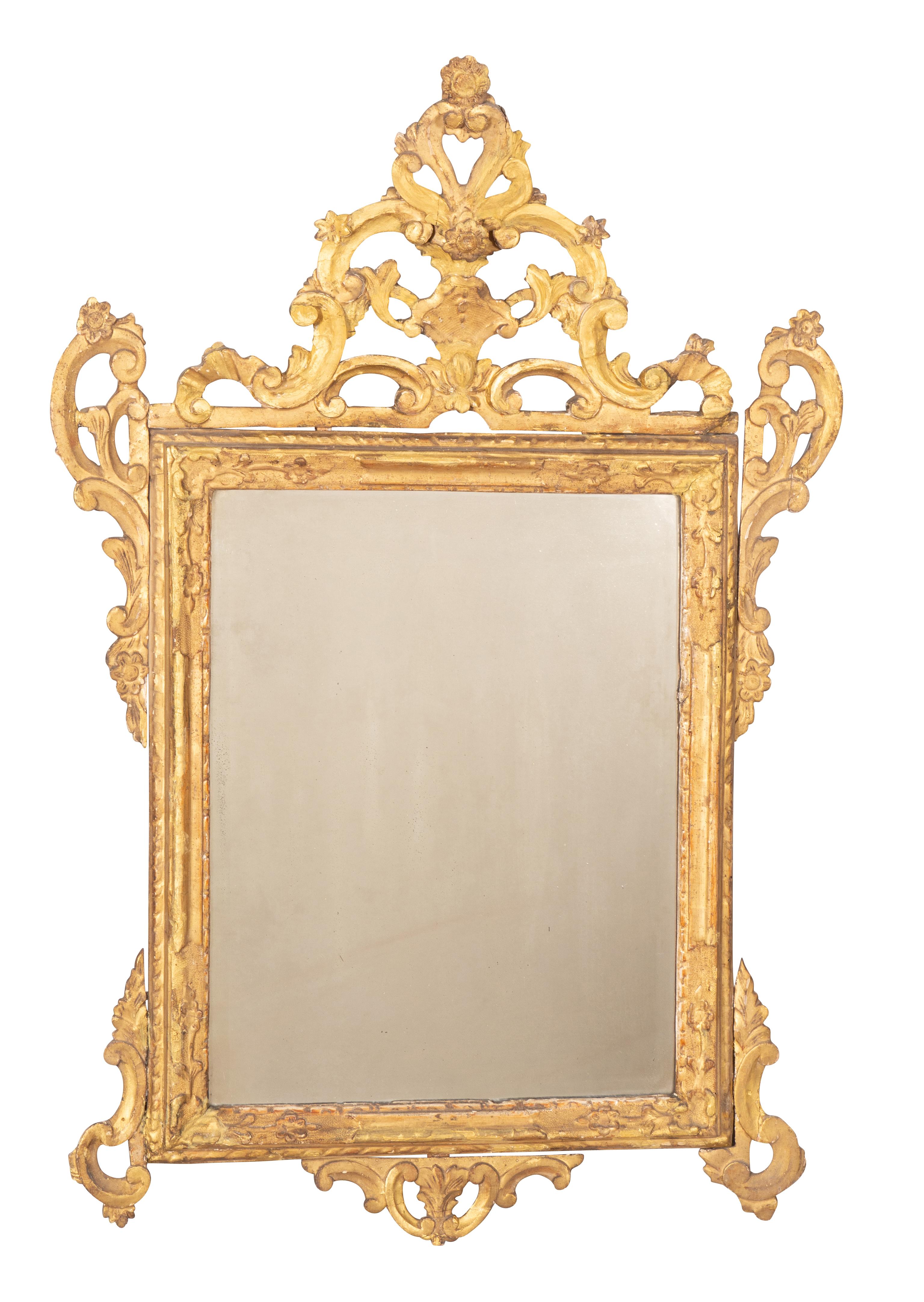 With original gilding in cleaned restored retail condition. Arched open crest with scroll and flower decoration over a mirror plate set in a conforming frame with open carved ear corners top and bottom.