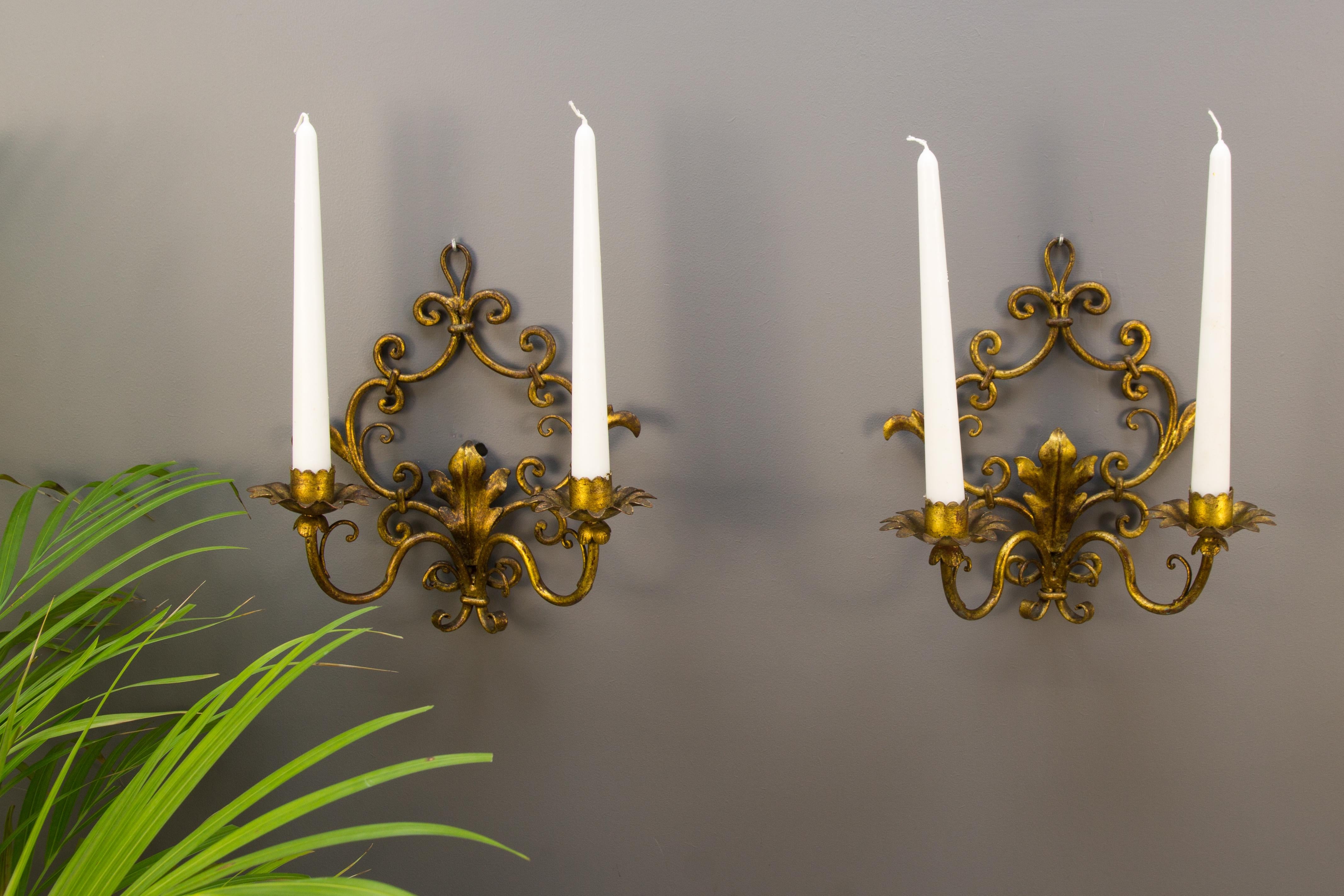 Pair of adorable Italian Hollywood Regency style two-light candle wall sconces with beautifully shaped gilt tole leaf-like details. Italy, circa the 1950s.
Measures: Height 25.5 cm / 10.03 in; width 25 cm / 9.84 in; depth 14 cm / 5.51 in.
In good