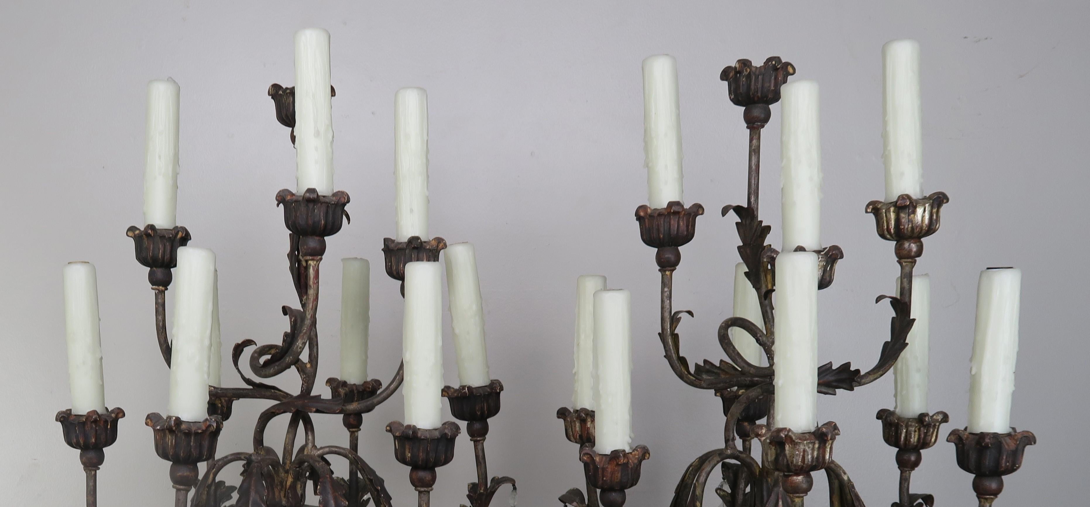 Pair of Italian Rococo style carved wood painted and parcel-gilt nine-light candelabra adorned with almond shaped rock crystals. Newly wired with drip wax candle covers and in working condition.