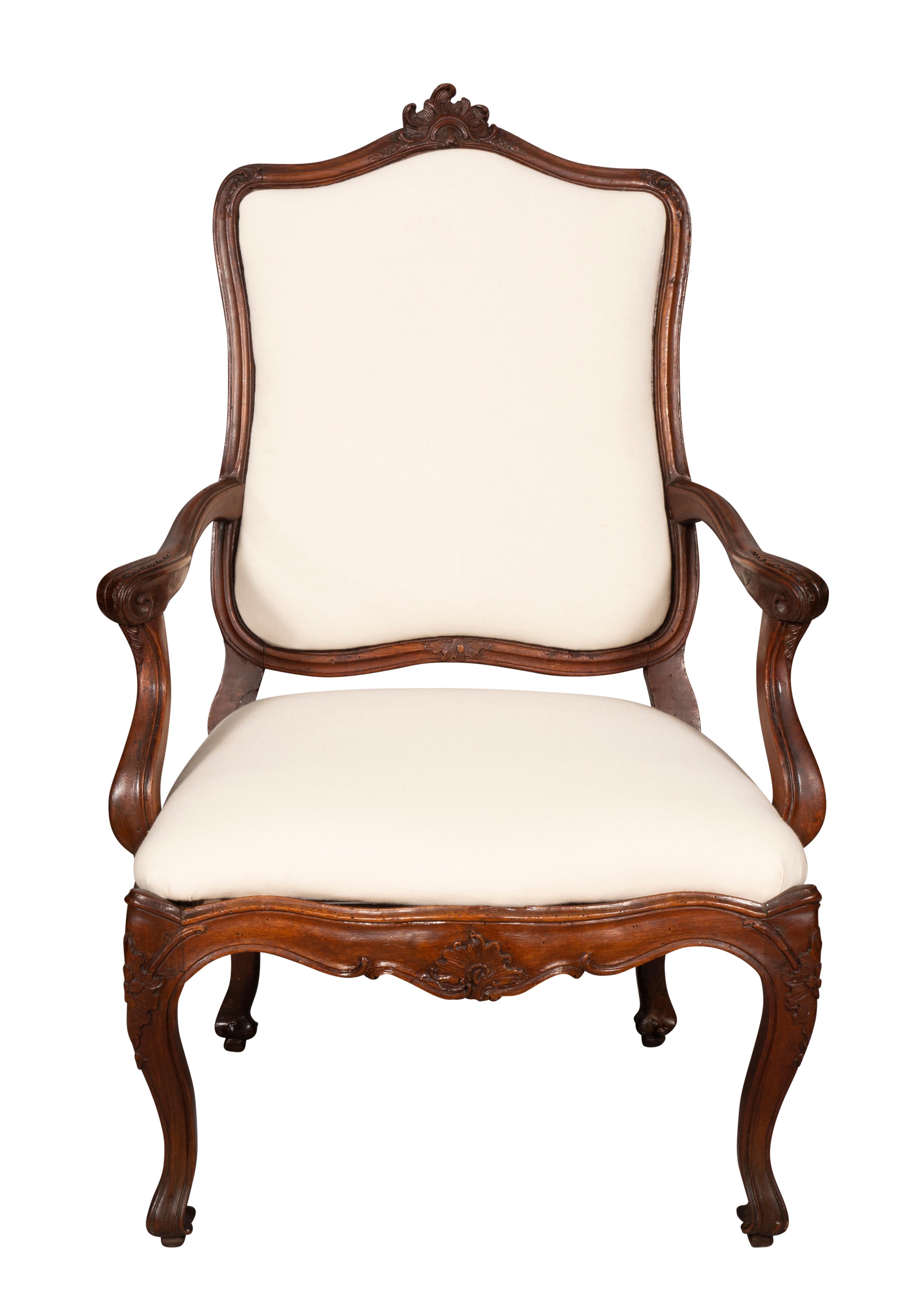 Great scale and generous proportions with arched back with central carved rocaille over an upholstered back and serpentine seat and conforming shaped seat rail with carved decoration. Well carved scrolling arms , raised on cabriole legs ending on