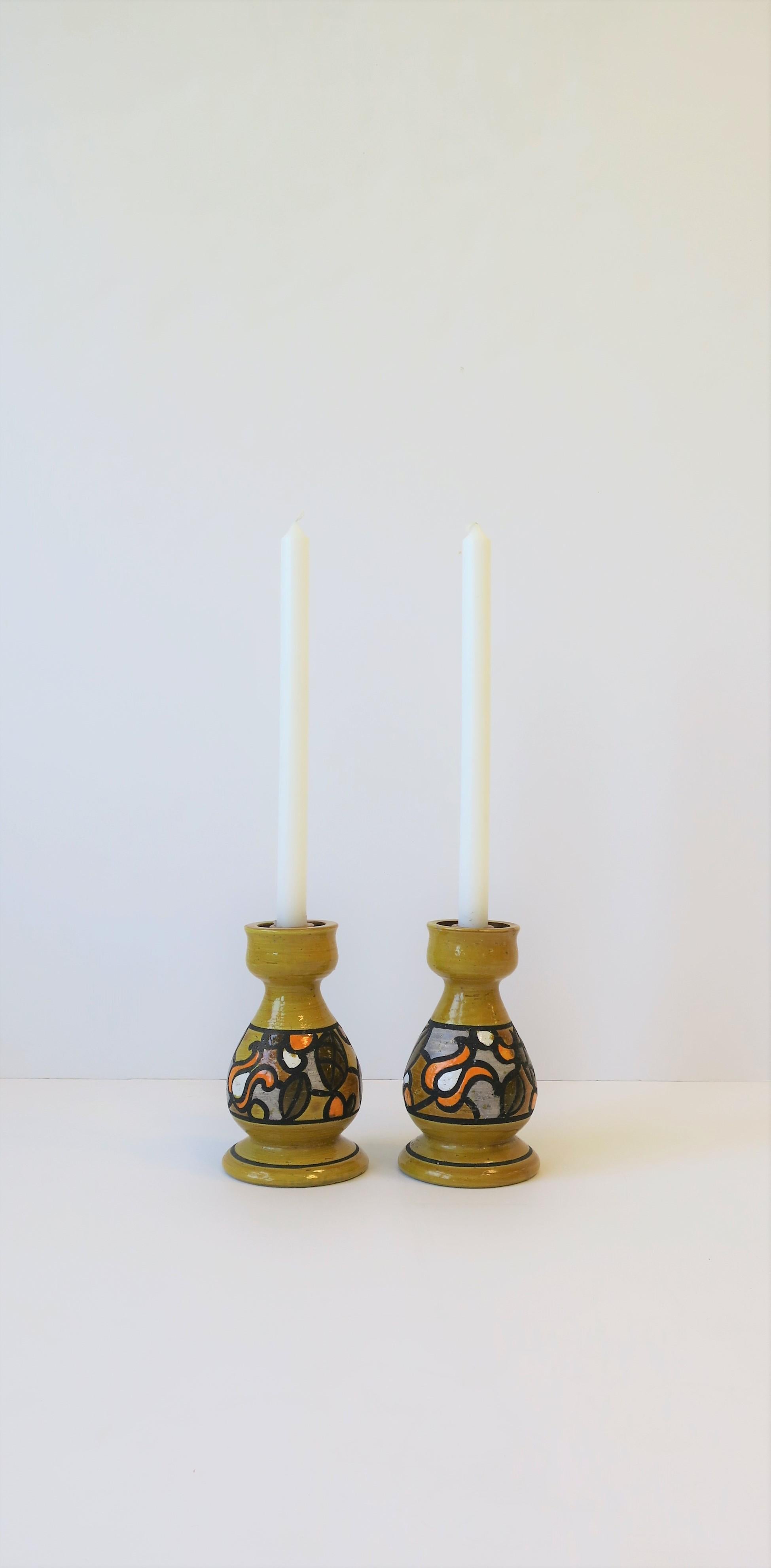 A beautiful pair of Italian pottery candlestick [candle stick] holders by Rosenthal-Netter, made in Italy, circa 1960s - early 1970s, 20th century. Colors include: golden-yellow, white, orange, grey, black/charcoal. Maker's mark on bottom as show in