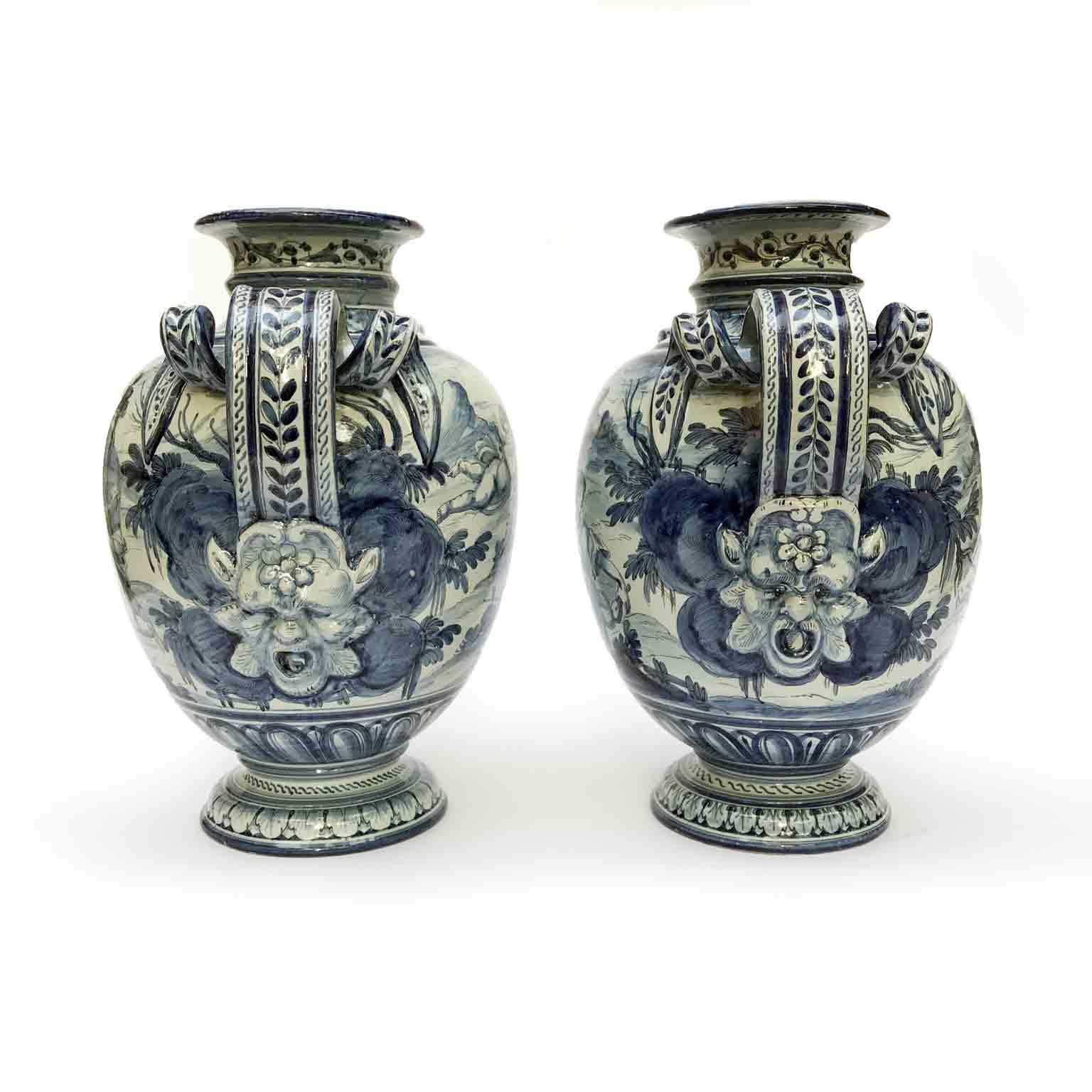 Very decorative pair of blue and white hand-painted vases from the famed Majolica production town of Savona, in Liguria region, Italy. 
Decorated all round with figural scenes with a seated woman and cherubs. Castles and mountains are in the