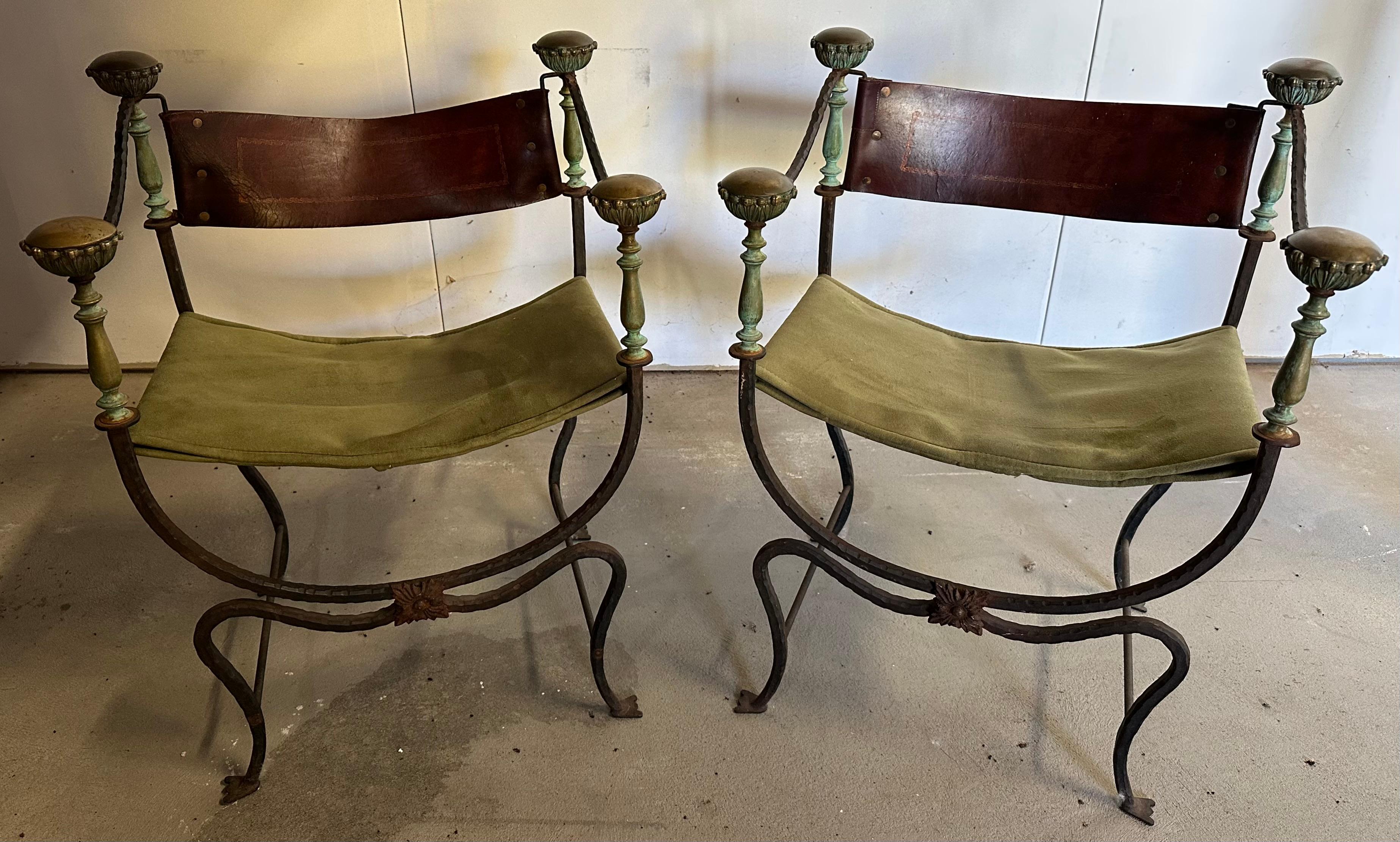 Cette rare paire de chaises Curule Savonarola, à l'origine destinées aux magistrats romains, est fabriquée avec des dossiers en cuir doré et estampé qui ont vieilli et une nouvelle assise en daim. Le cadre en fer joliment patiné et les montures en