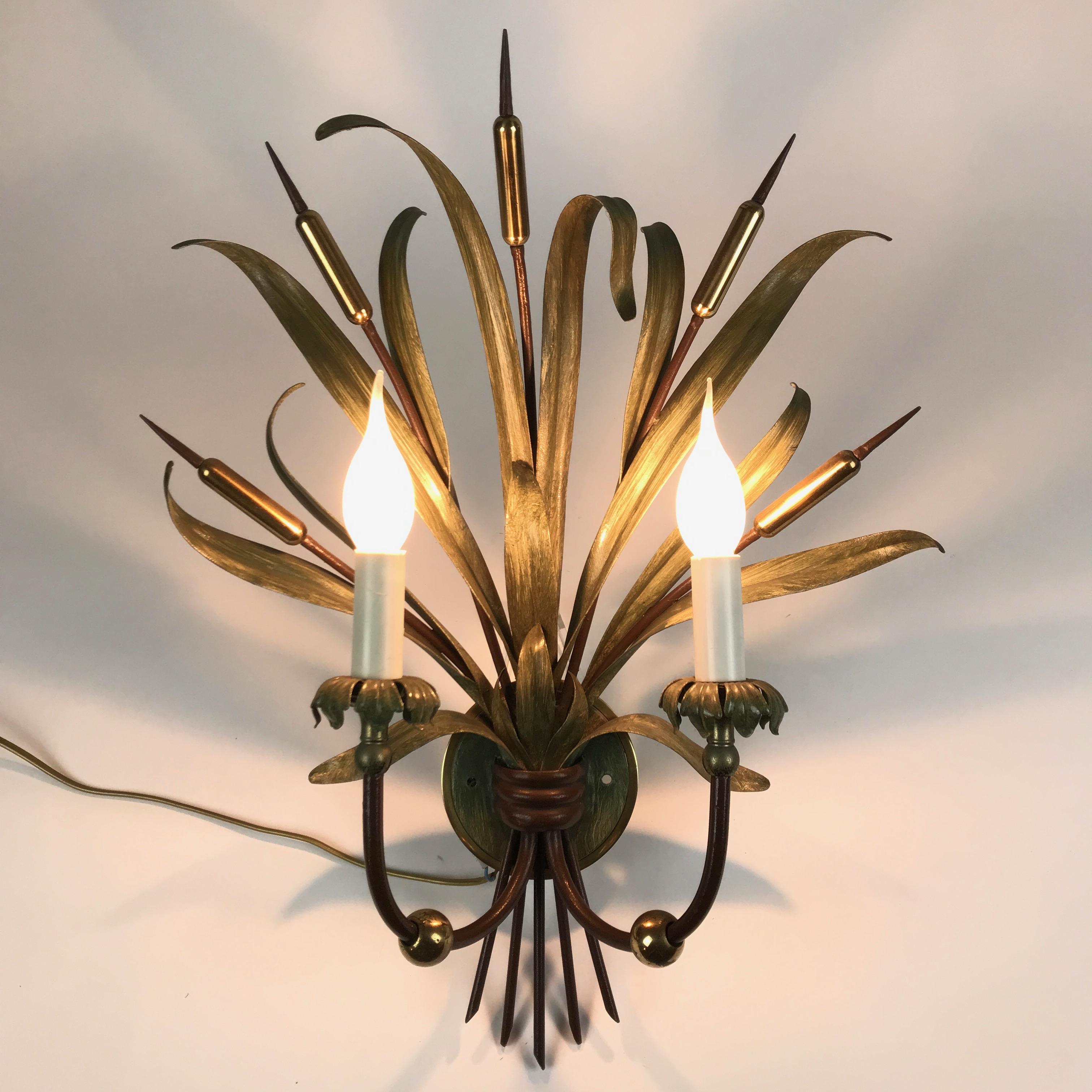 A late 20th century pair of Italian iron two armed sconces with green hand painted finish, two-light sconces by Banci, manufactured by Banci Firenze.  
These two original Italian iron wall-lights are realized with a  green foliate structure, a bunch