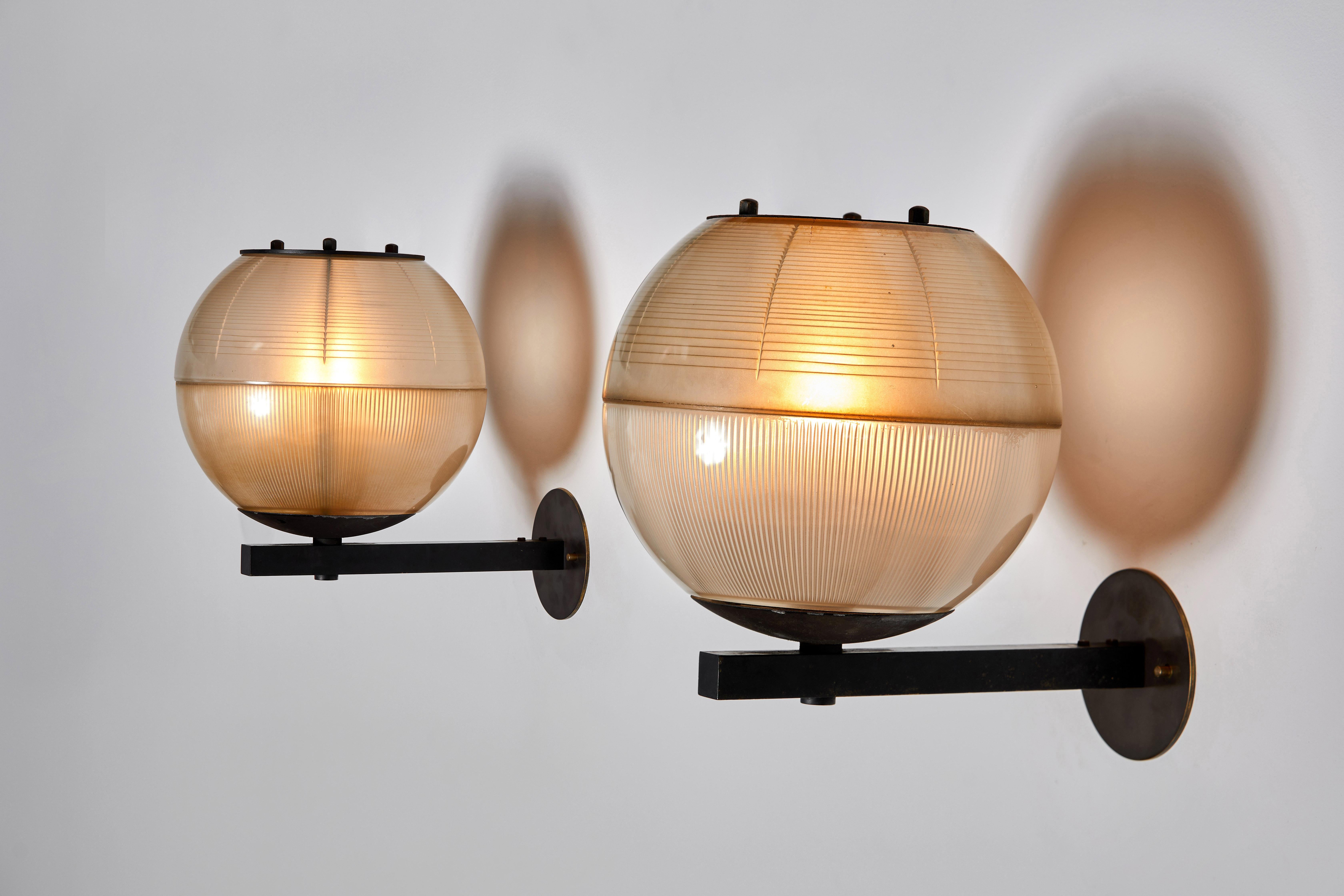Pair of sconces manufactured in Italy, circa 1960s. Blackened metal with holophane glass diffuser. Rewired for U.S. junction boxes. Custom fabricated backplates. Each light takes one E27 100w maximum bulb. Bulbs provided as a onetime courtesy.