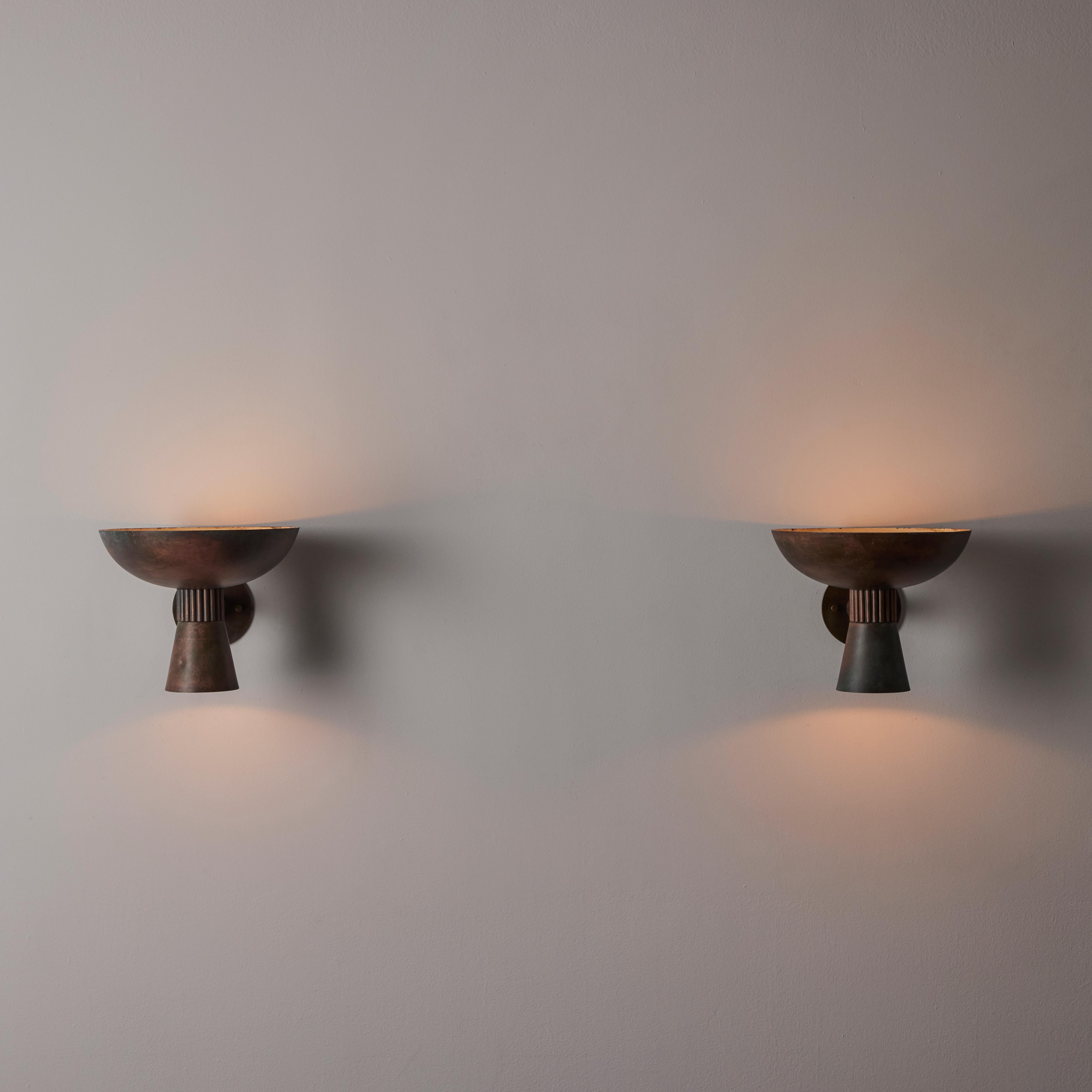 Pair of Italian Sconces. Designed and manufactured in Italy, circa the 1940s. Beautifully aged copper double end sconces. Upper dish and lower flute receive illumination with an enameled interior finish. Each shade holds a single e14 socket type,