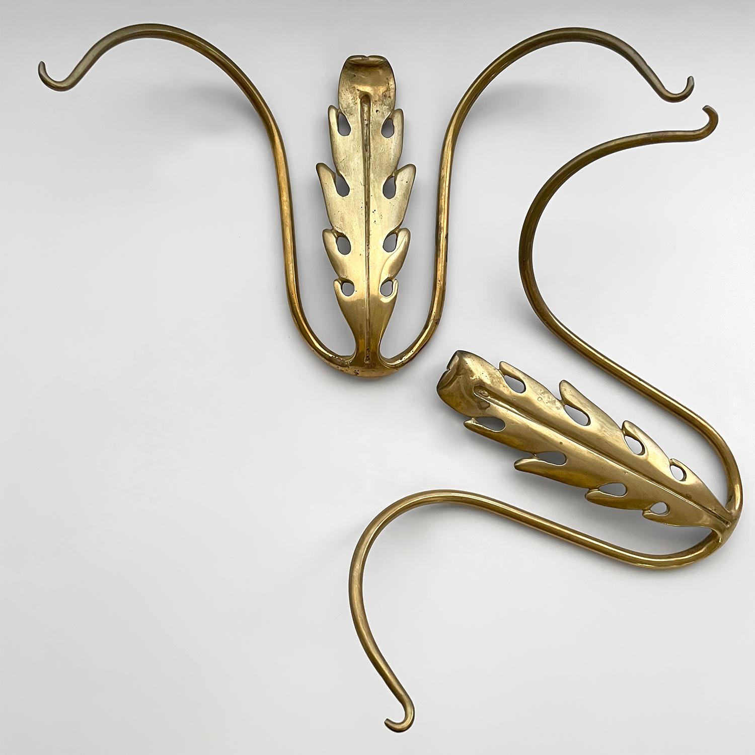 Stunning pair of Italian sculpted brass double wall hooks
Italy, 1950’s 
Timeless classic  that will brighten any wall space
Beautifully sculpted brass
Floral motif centerpiece with delicately curved arms
Each hook has a single wall mount
Patina