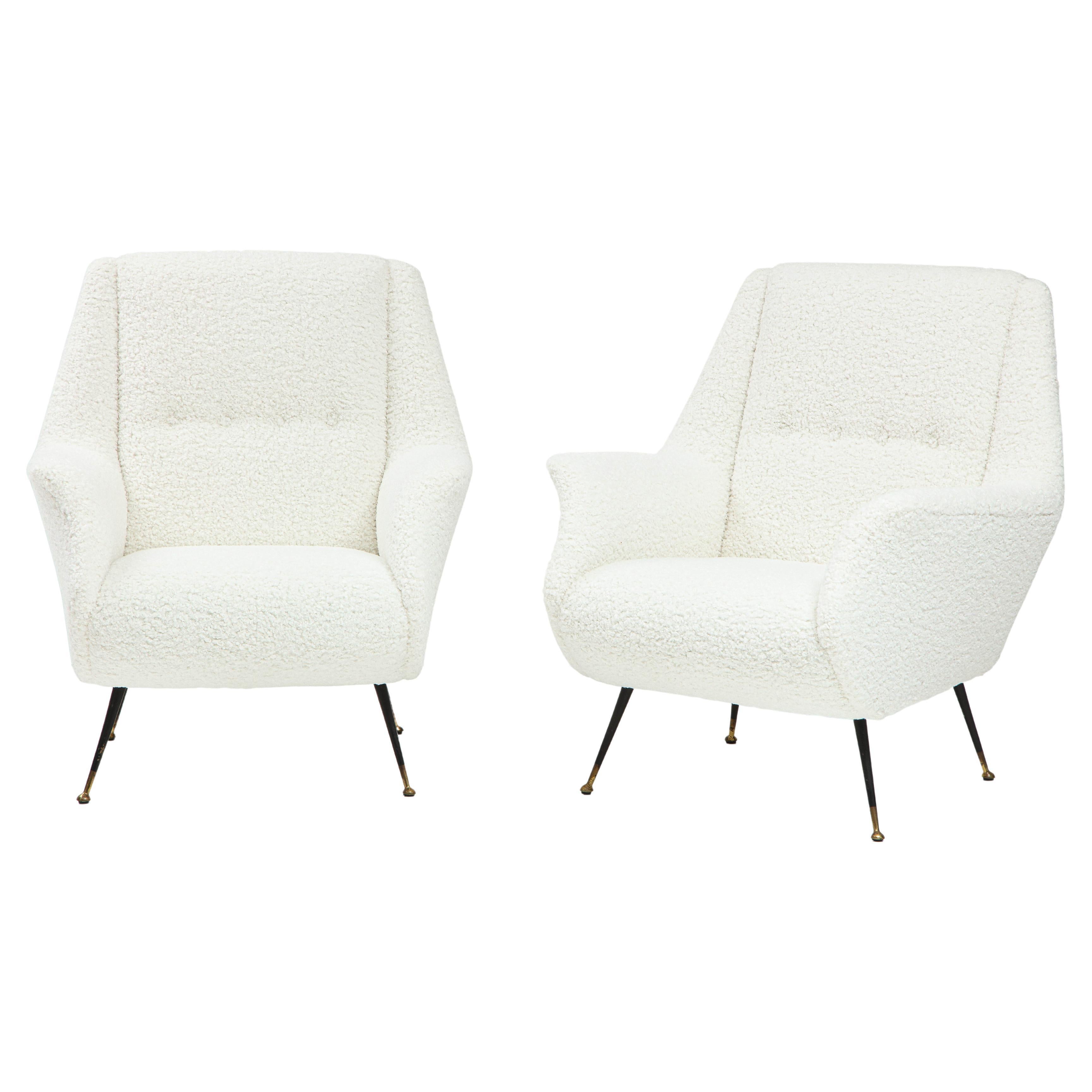 Pair of Northern Italian sculptural armchairs, the arms elegantly splayed, the whole newly upholstered in a creamy white faux shearling, with chic black metal and brass tapered legs. 
Northern Italian, circa 1960
Size: 35