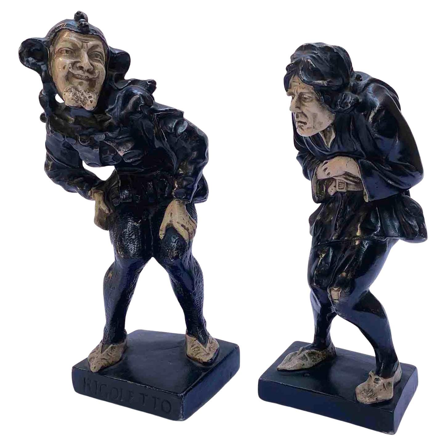 Pair of Grotesque Caricature figurines of the first half of 20th century. One figurine depicting Rigoletto, the deformed jester from the famous Verdi opera with the famous aria La donna è mobile. The standing sculpture is made of patinated plaster