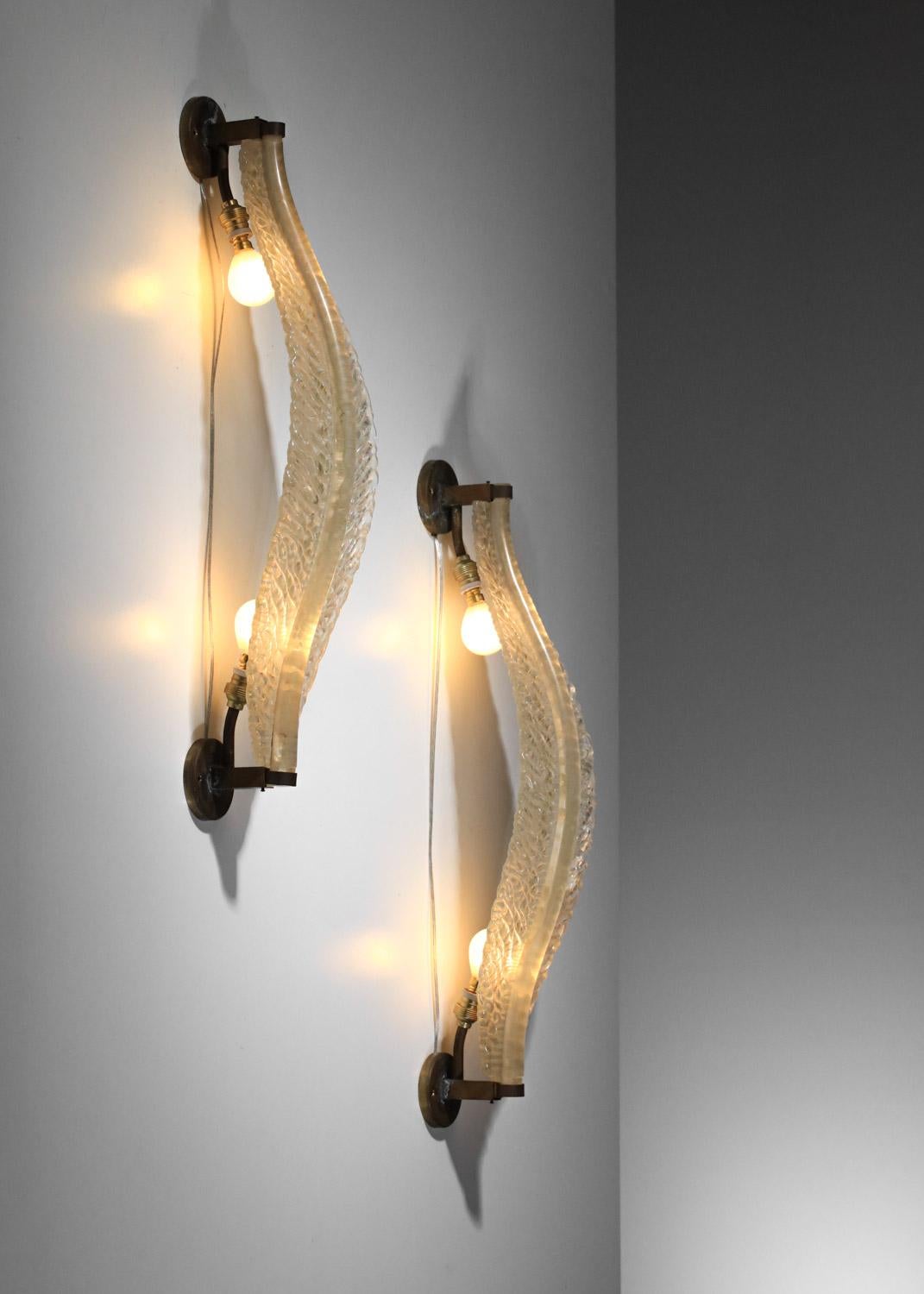 Large pair of Italian wall sconces from the 1940s by the Venetian manufacturer Seguso. Patinated solid brass frame, large iridescent Murano glass shade with leaf-shaped inclusions of gold glitter within the glass. Very good vintage condition, note