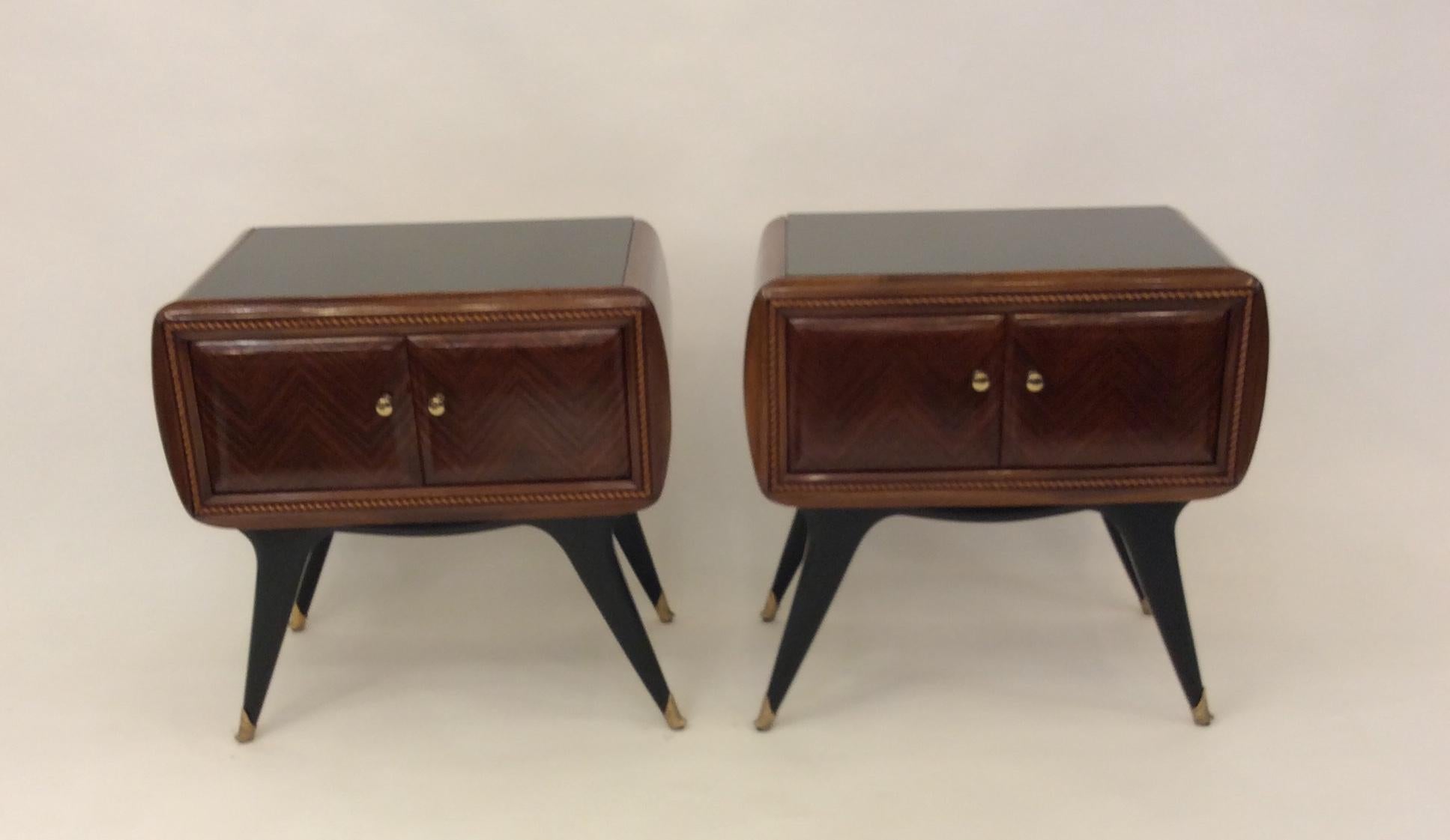 A fantastic pair of midcentury Italian designed side chests in exotic wood with amazing marquetry double doors black glass top, sculptural black lacquered legs leading to brass shoes could work as night stand or side chests amazing quality