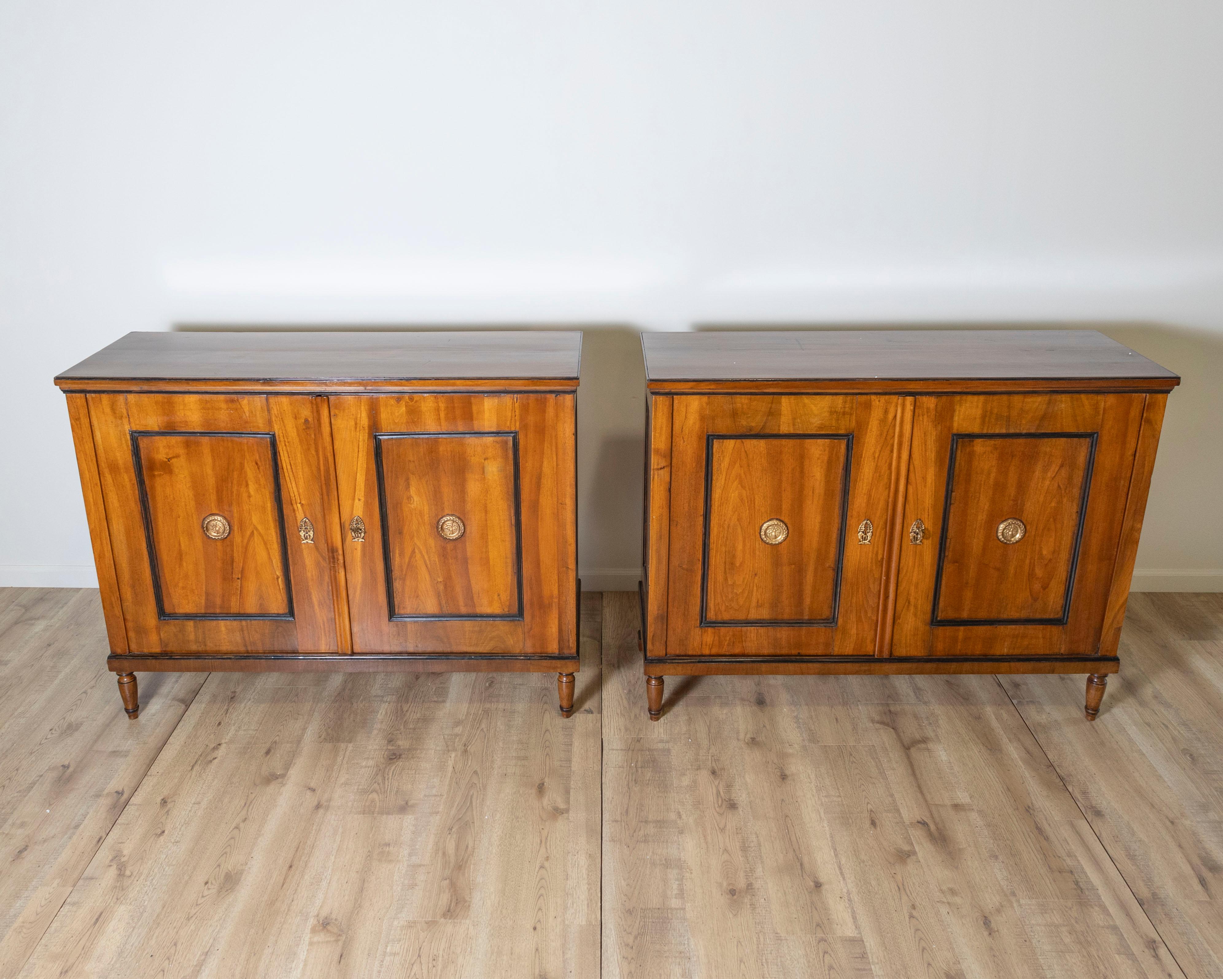 Ein raffiniertes Paar italienischer Anrichten aus dem späten 19. Jahrhundert, wunderschön gefertigt aus warm getöntem Nussbaumholz mit neoklassischer Inspiration. Diese eleganten Schränke zeichnen sich durch klare Linien und symmetrische