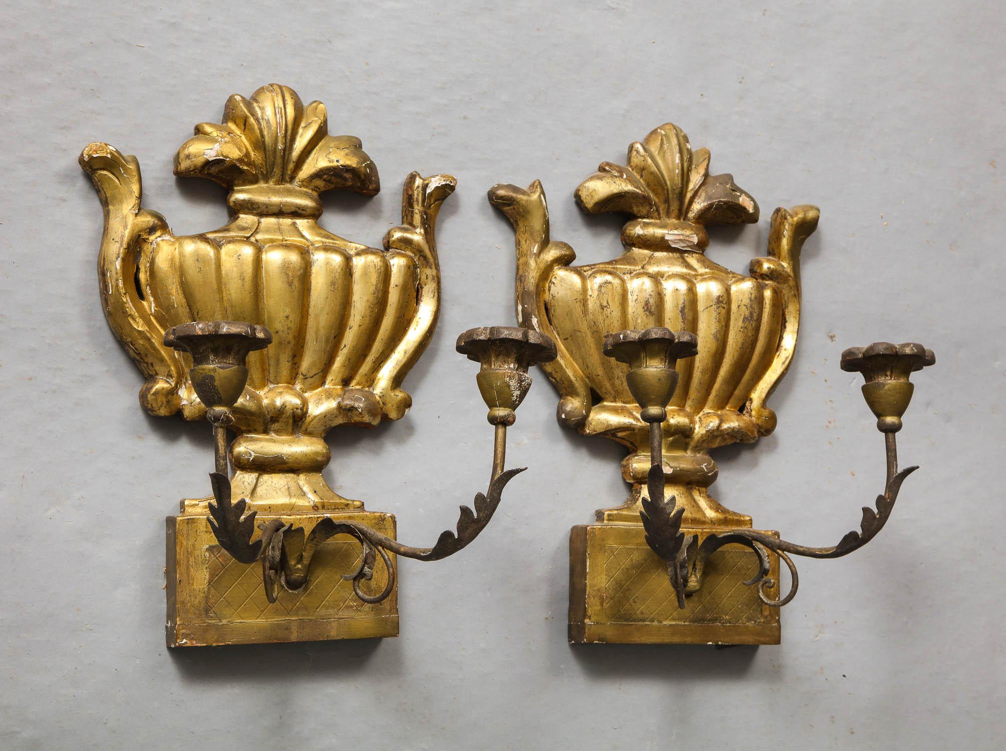 Good pair of 18th century Italian carved and silver gilt wall lights having ribbed urn backs and two wrought irons scrolled arms with giltwood bobeches.