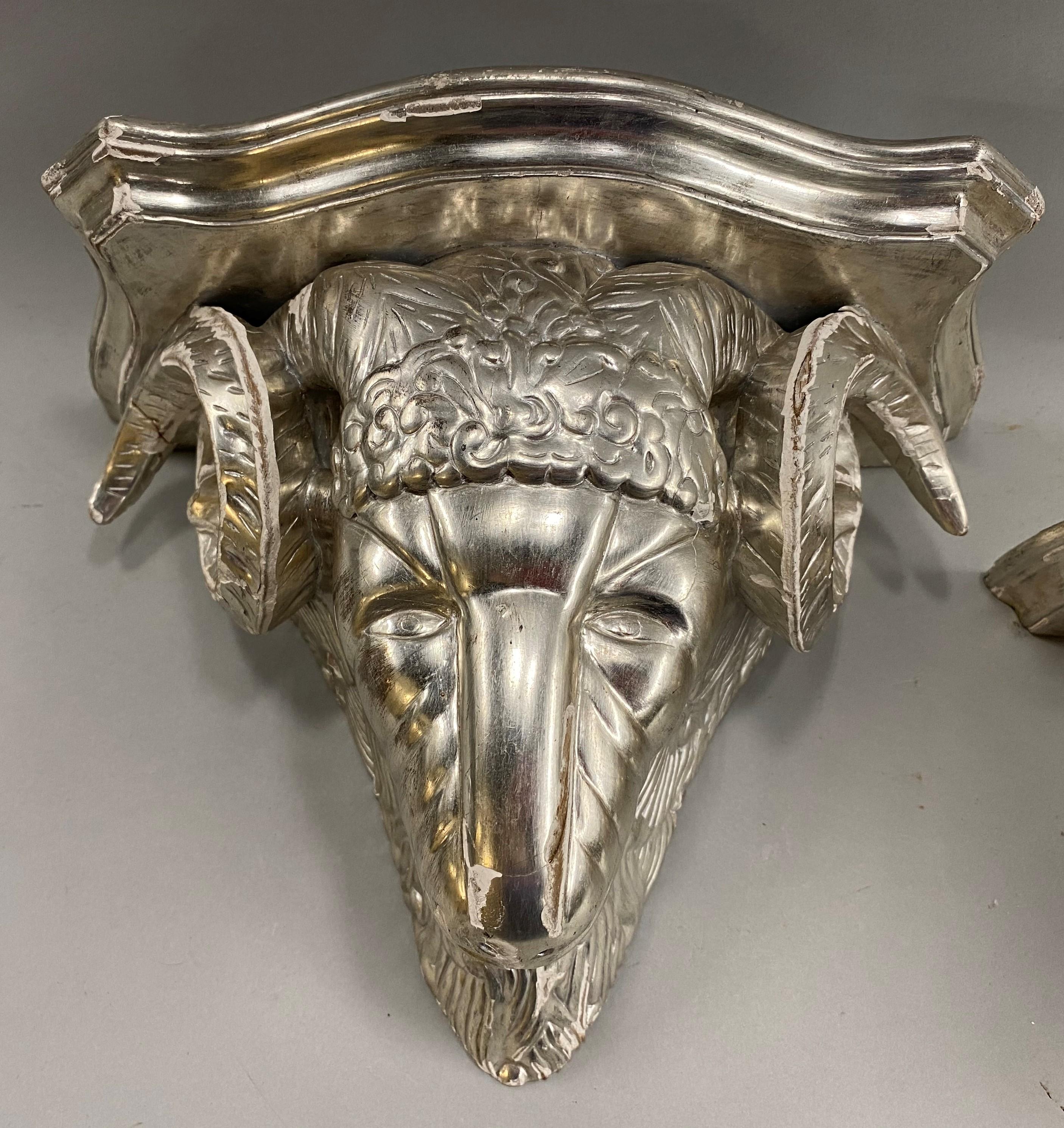 A fine Italian decorative pair of silver leaf ram’s head figural wooden wall brackets with shaped tops, lightly distressed, dating to the 20th century, in very good overall condition, with intentional edge leaf losses, other minor imperfections and