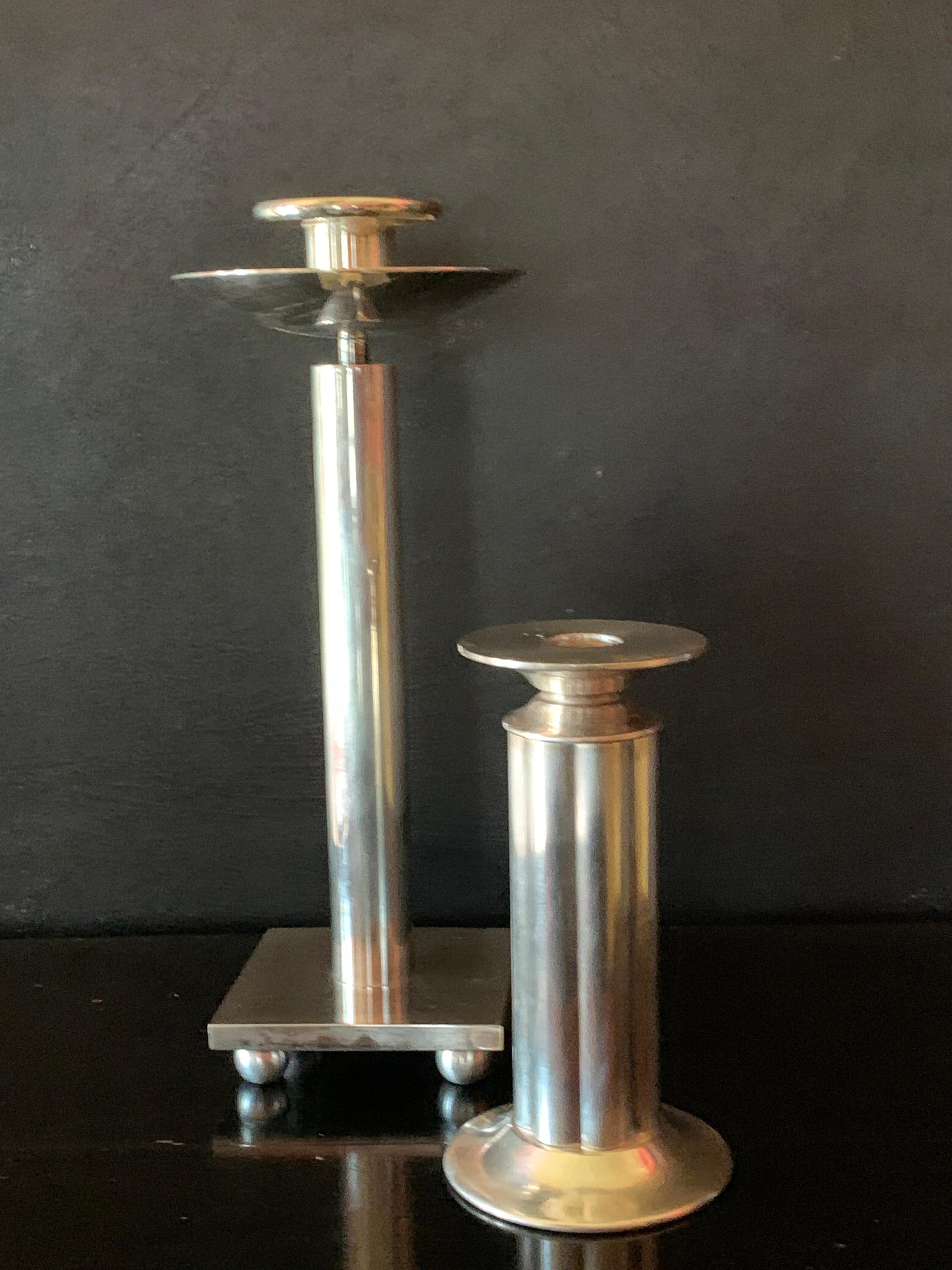 Stunning and architectural, the pair of silver plate candle sticks by Architect Richard Meier for Swid Powell are a collectors dream!

The taller of the two is simple, yet stunning and very solid - the shorter is ribbed and a delightful companion.