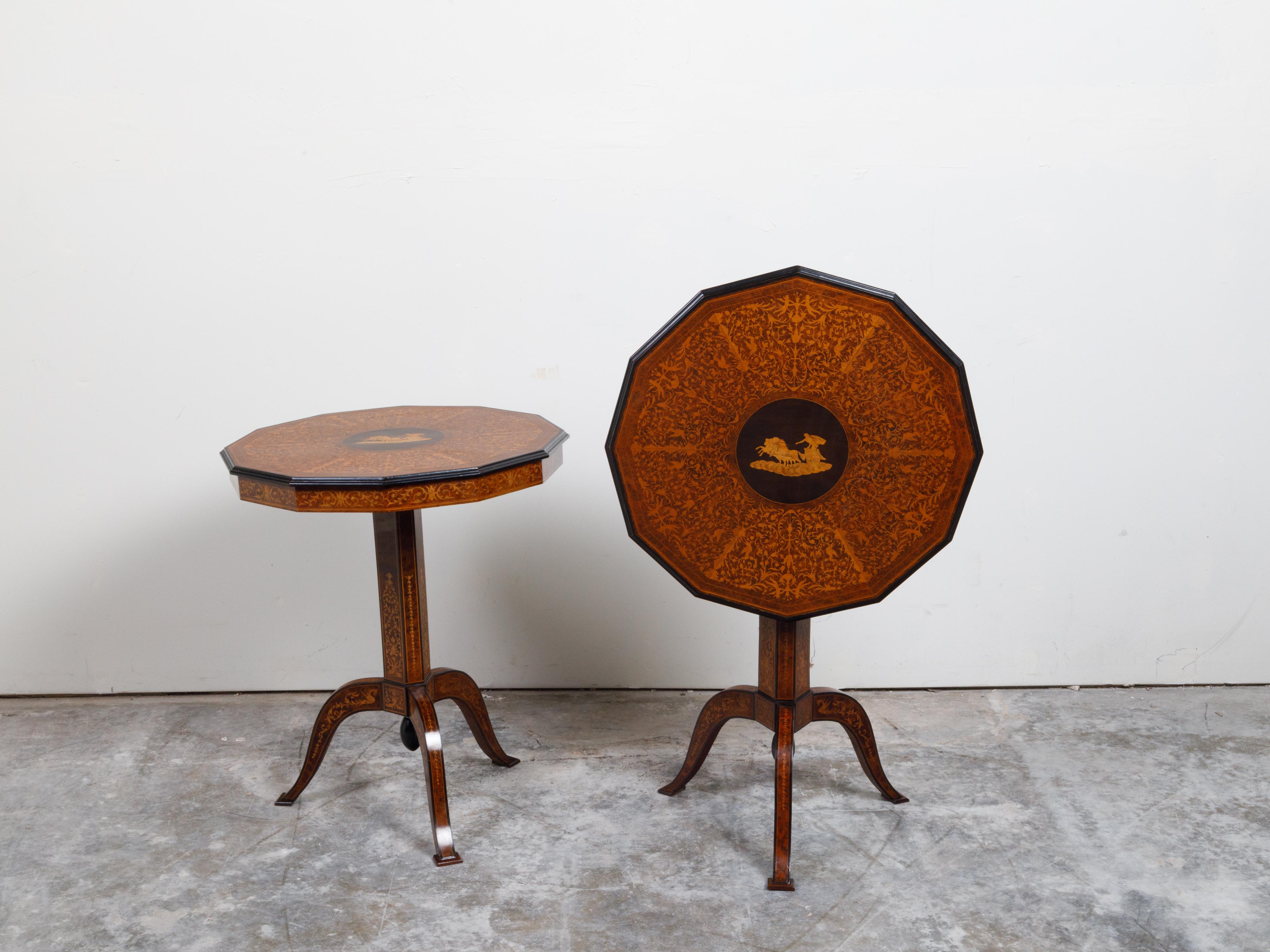 A pair of Italian Sorrento tilt top tables from the 19th century, with marquetry Mythological scene and pedestal bases. Created in Italy during the 19th century, each of this pair of side tables features a 12-sided top adorned with a mythological