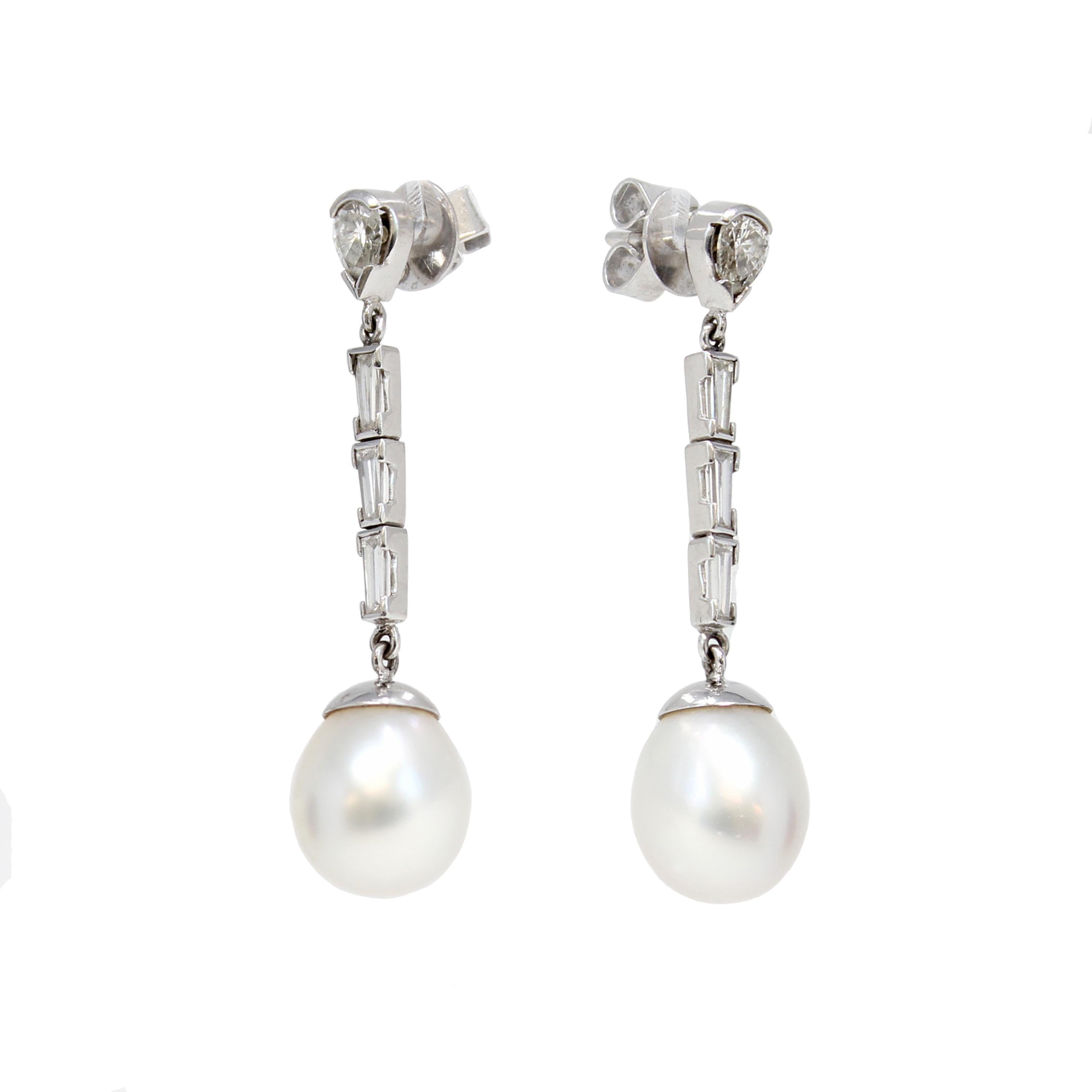 A pair of Italian South Sea Pearl and Diamond dangling earrings in 18K white gold, circa 1960. Created in Italy during the mid-century period, each of this pair of earrings features an Australian 11.5mm white drop-shape Pearl with very good luster