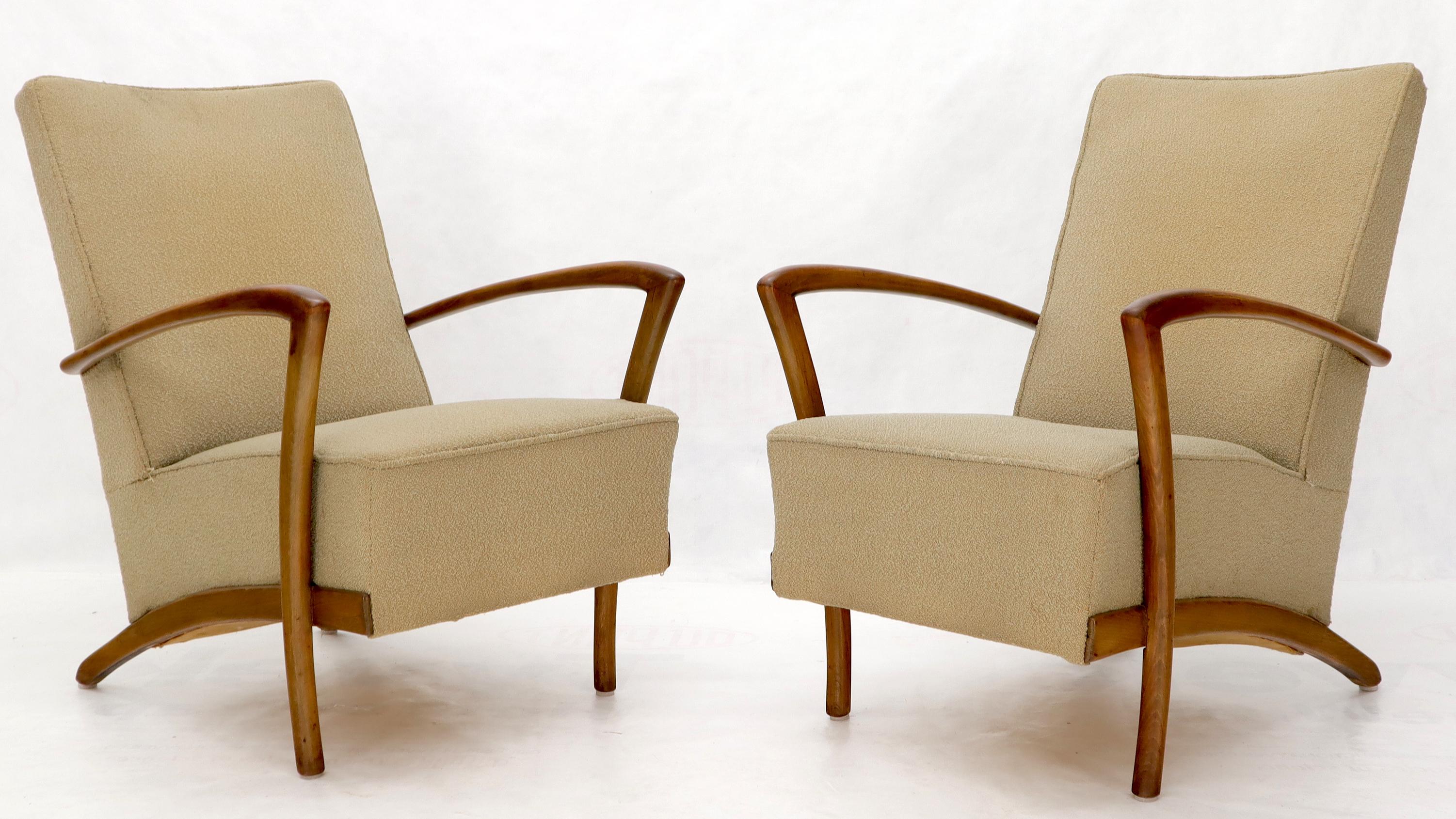 Pair of Italian Mid-Century Modern wooden arms springs loaded arm lounge chairs.