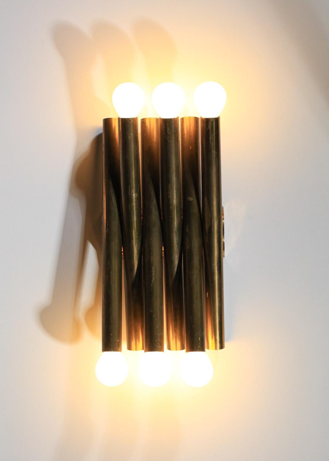 Pair of 60's sconces by Stilnovo. Structure in solid, patinated brass tubes that intertwine for a highly decorative, graphic effect. Beautiful vintage condition, with traces of age and oxidation on the brass (see photos). Electrical system