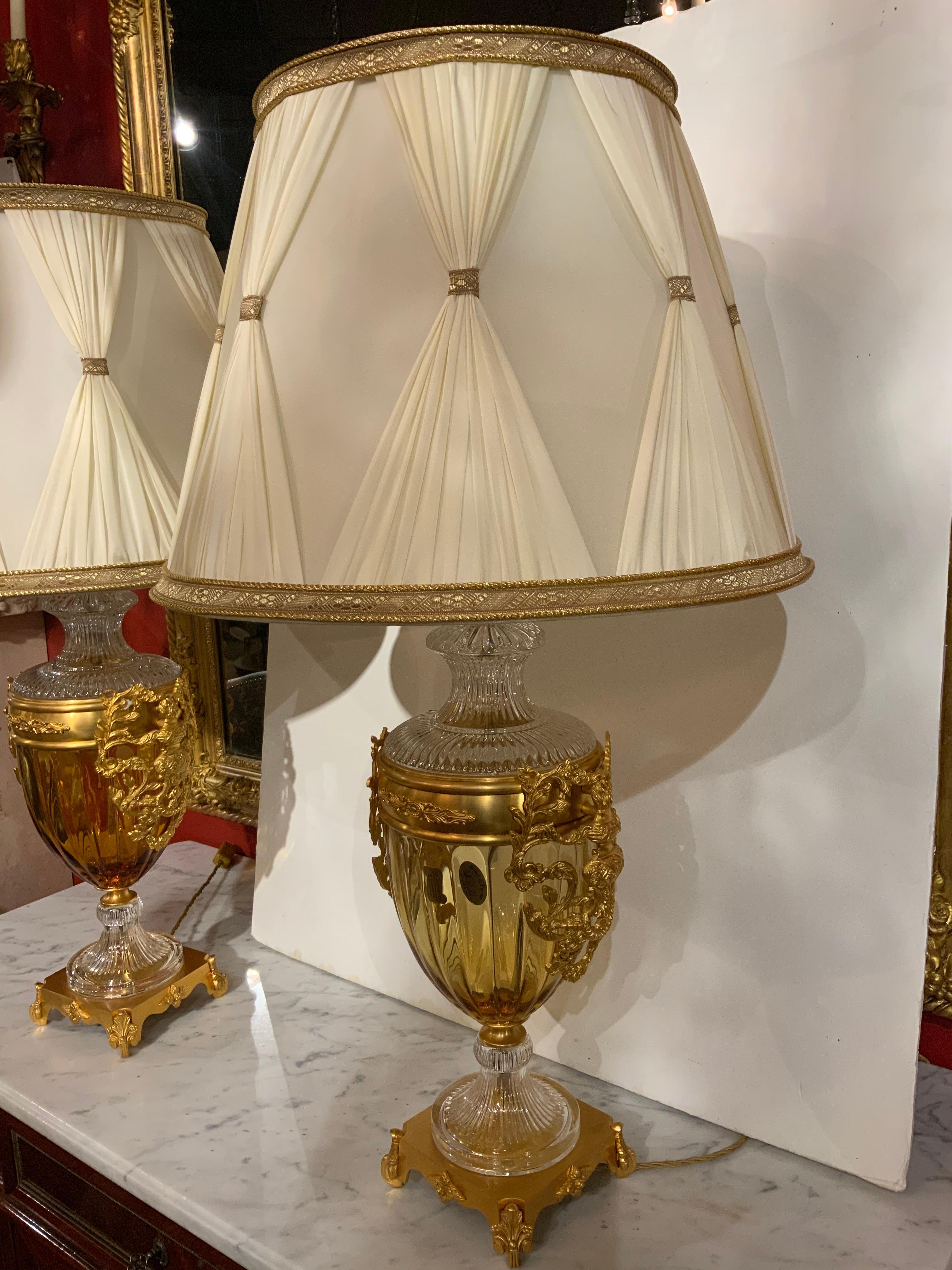 Pair of crystal and bronze dore lamps by manufacture 
Baldi that is known for their superior quality. The crystal 
Is 24 percent lead crystal and is on a bracket foot that
Supports the lamp. The crystal is a pale gold hue and
Is in an urn shape.