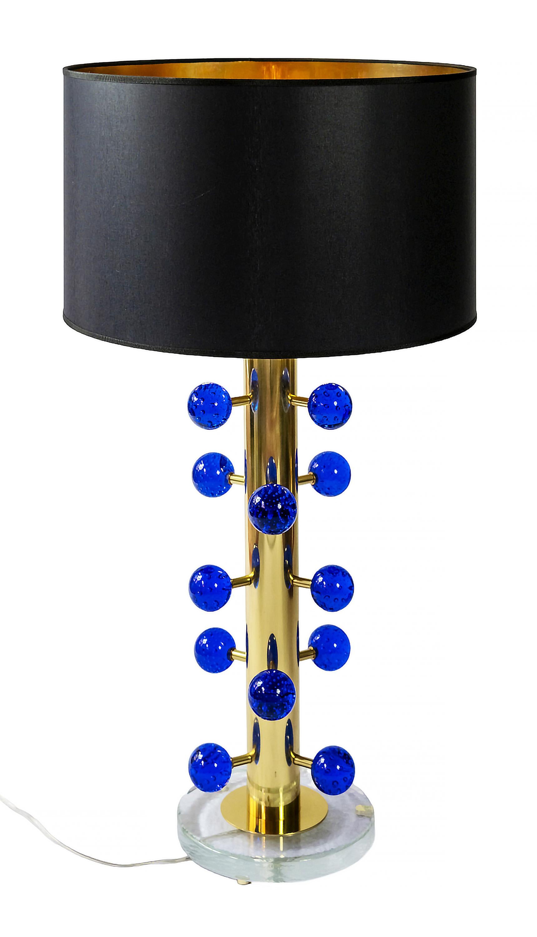 Pair of Italian table lamps are made of solid brass and glass base with small brass legs.
Decorated with blue colour Murano glass details.
Both lamps are with new made satin finish black colour textile shades with gold inside.
 