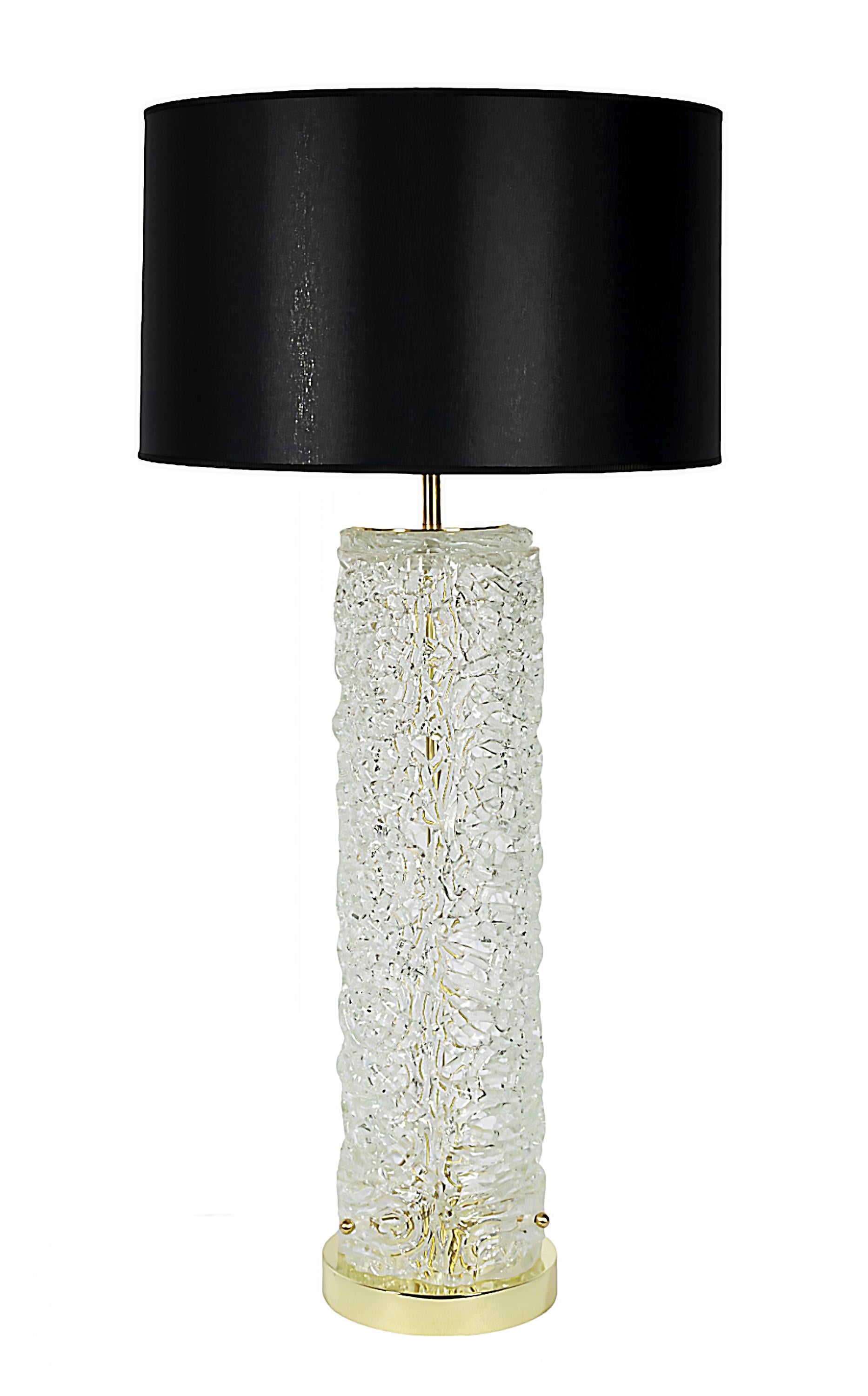 Pair of Italian table lamps made of transparent, textured and openwork Murano glass.
The base is in round brass. 
Both lamps are with new made black satin textile shades.
Dimensions: 
High 91 cm (incl. shade), shade high 27 cm, glass diameter 15